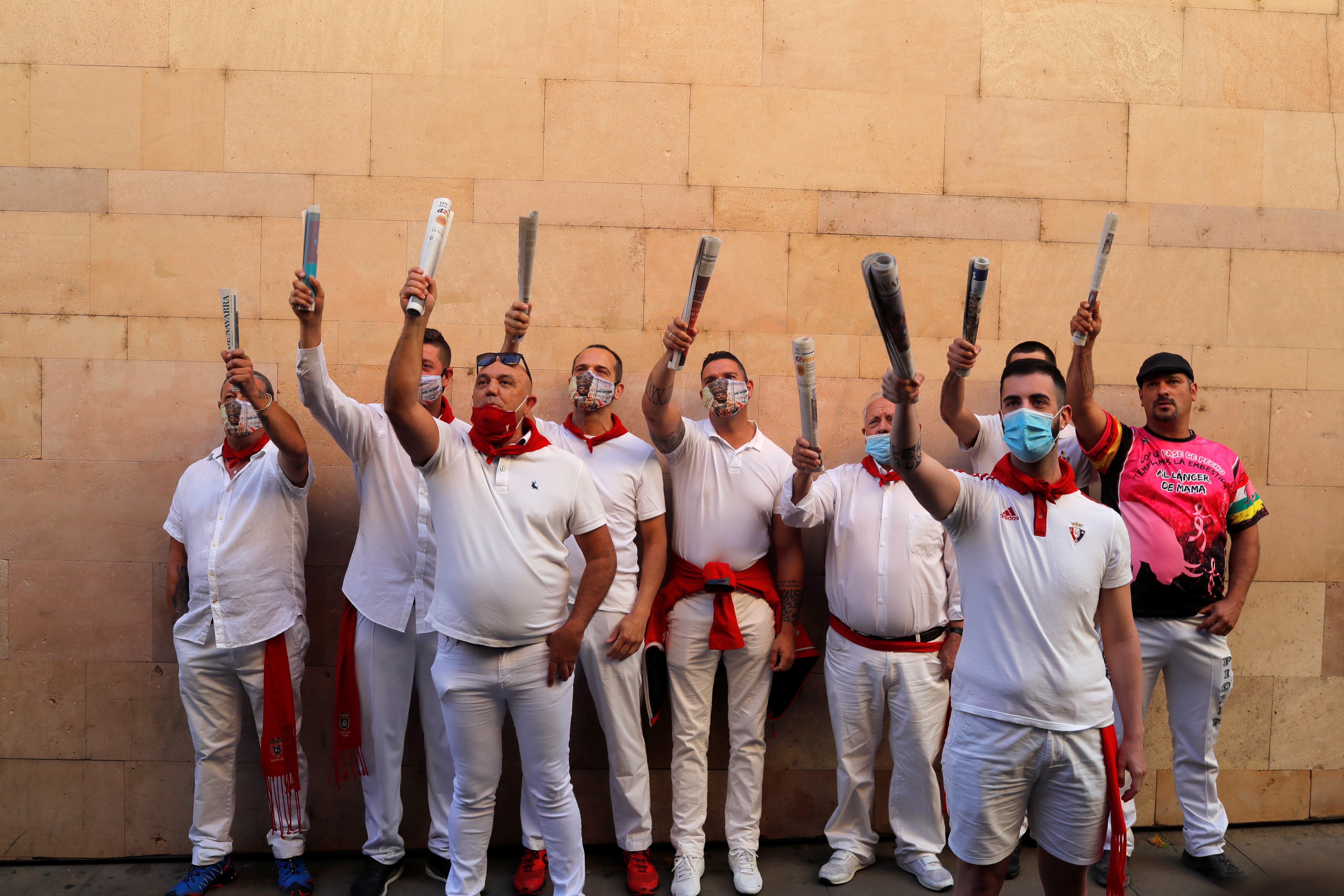 Un grupo de personas quiso celebrar, vestidas de blanco y rojo, como es tradición, el inicio de estos “no sanfermines” en la plaza consistorial. (REUTERS/Jon Nazca)