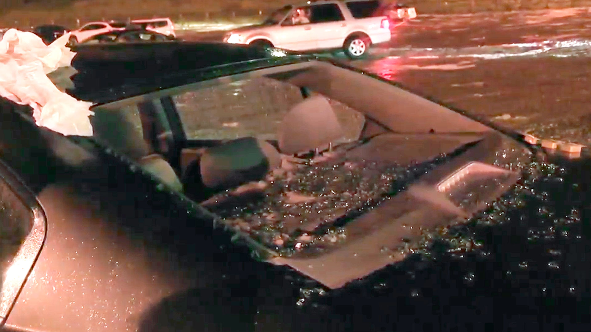 En esta imagen tomada de vídeo, el granizo rompe una ventana de un vehículo durante una tormenta en el Red Rocks Ampitheatre, la noche del miércoles 21 de junio de 2023, en Morrison, Colorado (Denver7 vía AP)

