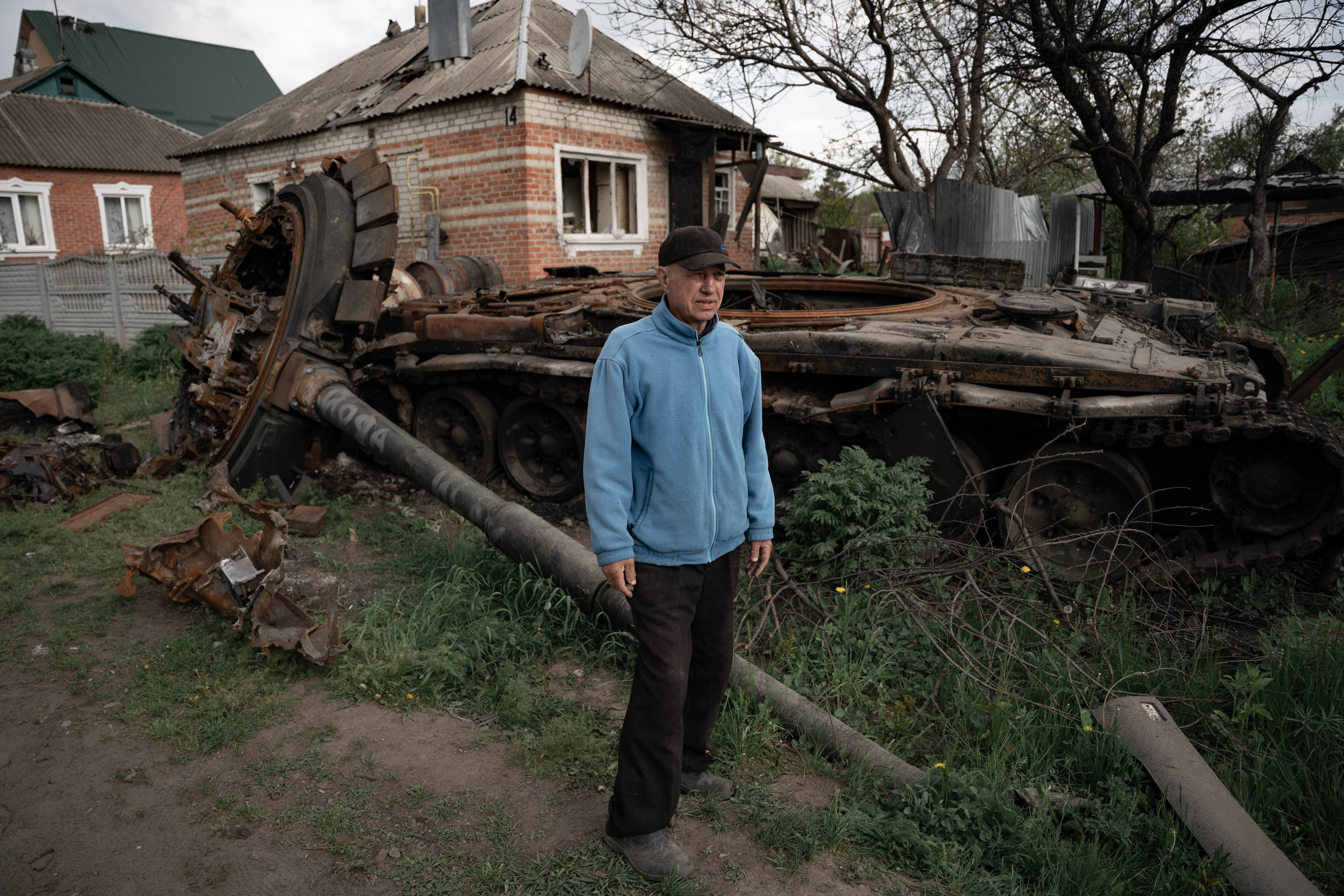 Panikaryov Mykola posa al lado de los restos del tanque ruso que están frente a su casa. Foto: Franco Fafasuli)