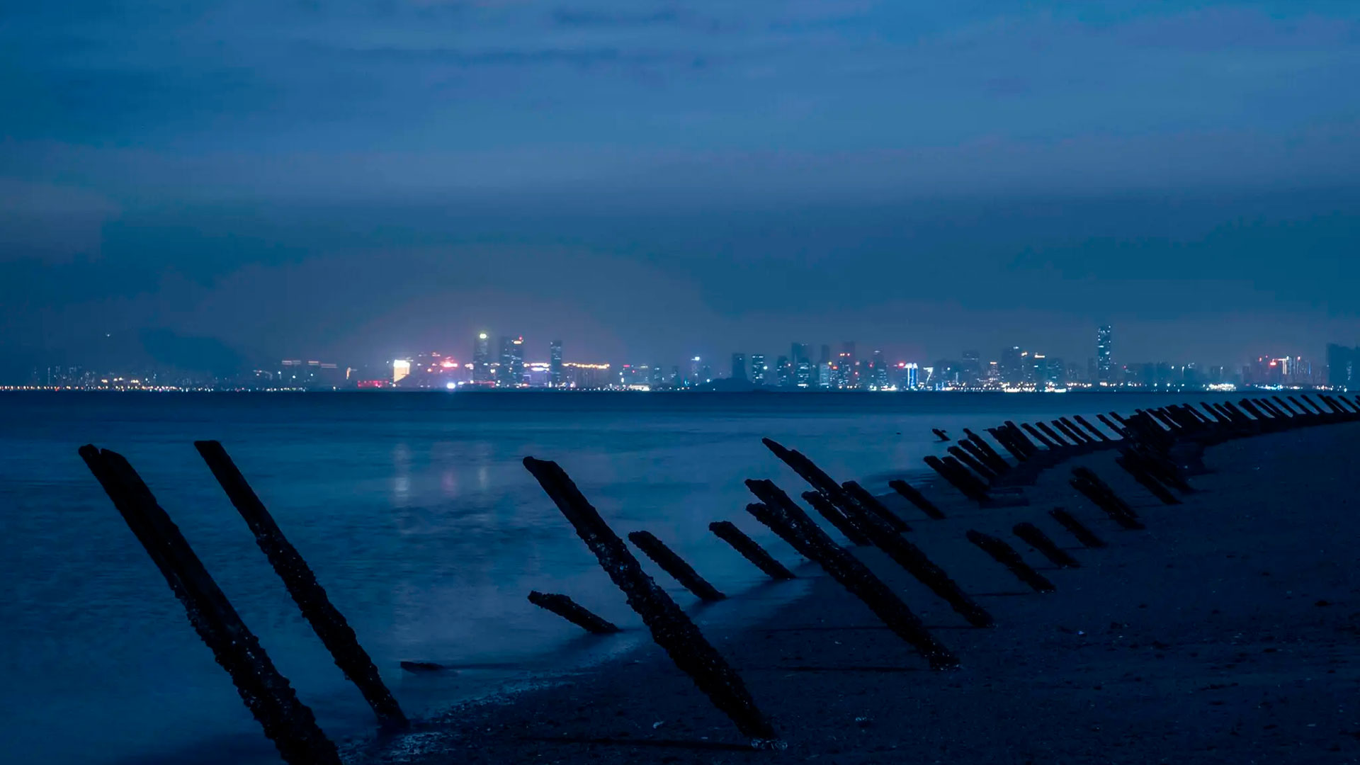 Barricadas anti-aterrizaje de décadas de antigüedad se alinean en la costa a lo largo de una playa en Kinmen, una isla periférica de Taiwán. La ciudad china de Xiamen está en la distancia (foto: New York Times)