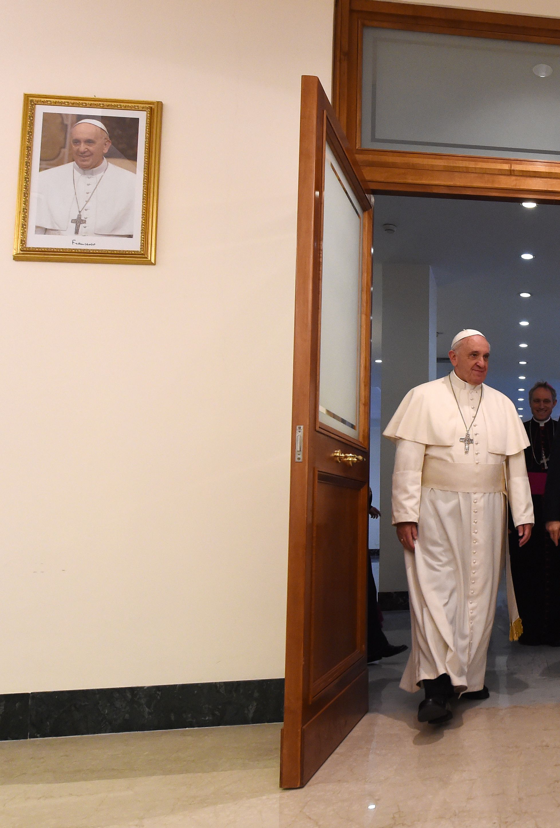 El Papa Francisco en la Casa Santa Marta, junto a un retrato suyo 