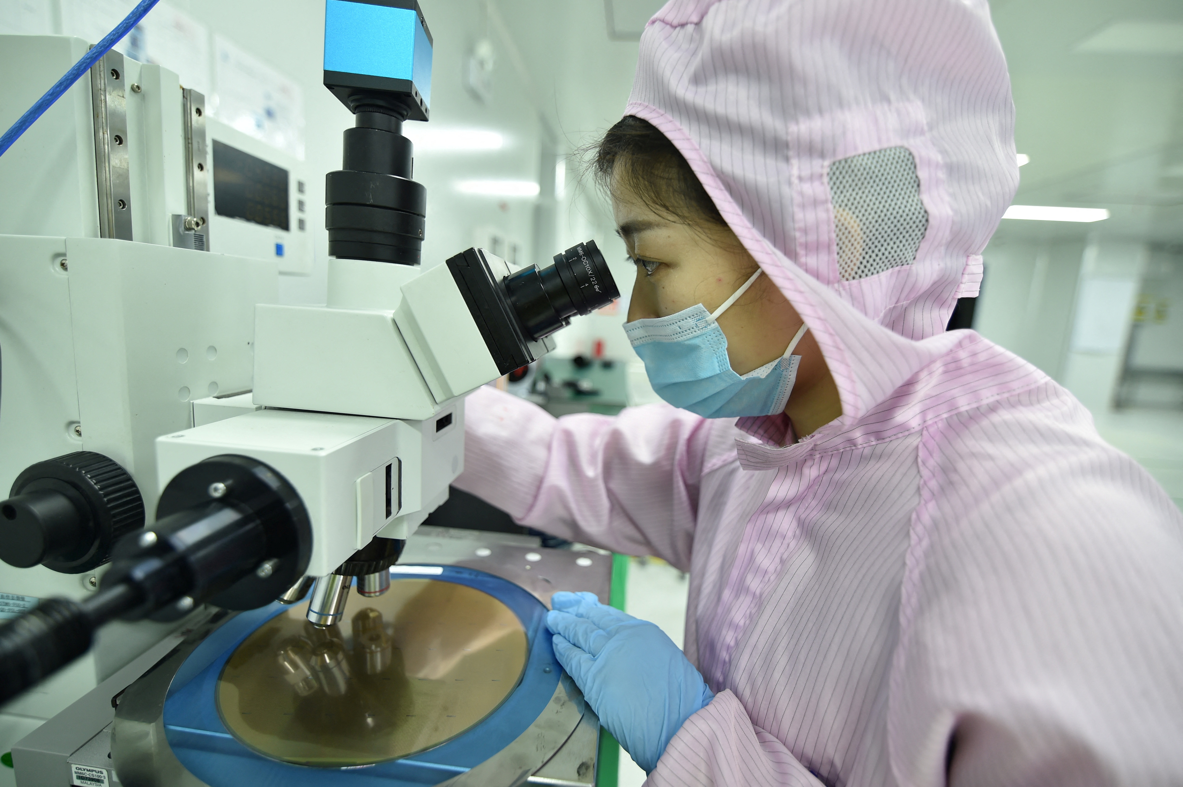 Un empleado inspecciona un chip en la empresa de chips semiconductores en Suqian, provincia de Jiangsu, China 28 de febrero de 2023. (China Daily via REUTERS)
