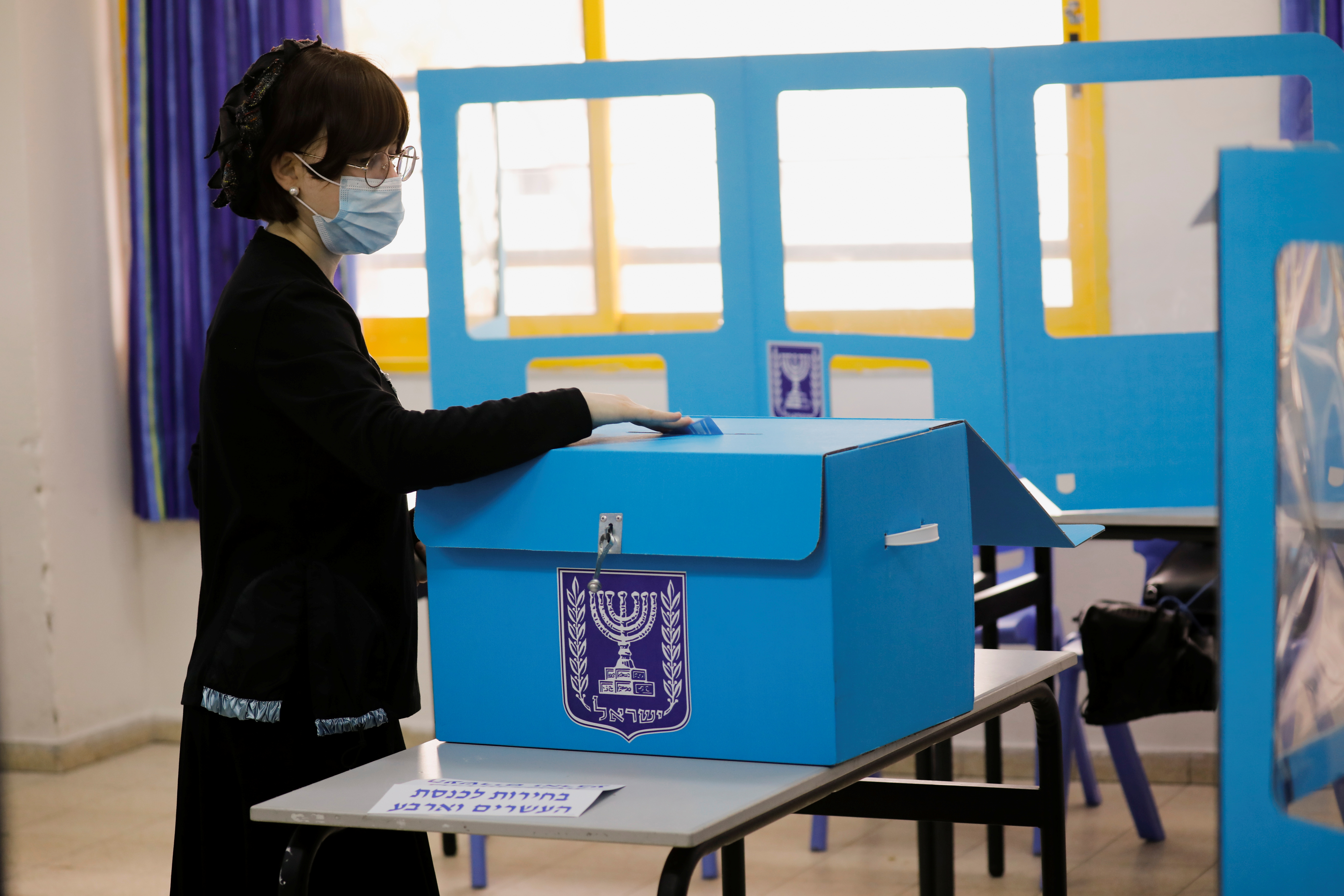Una mujer judía ultraortodoxa emite su voto en las elecciones generales de Israel en un colegio electoral en Ashdod, Israel, el 23 de marzo de 2021. REUTERS / Amir Cohen