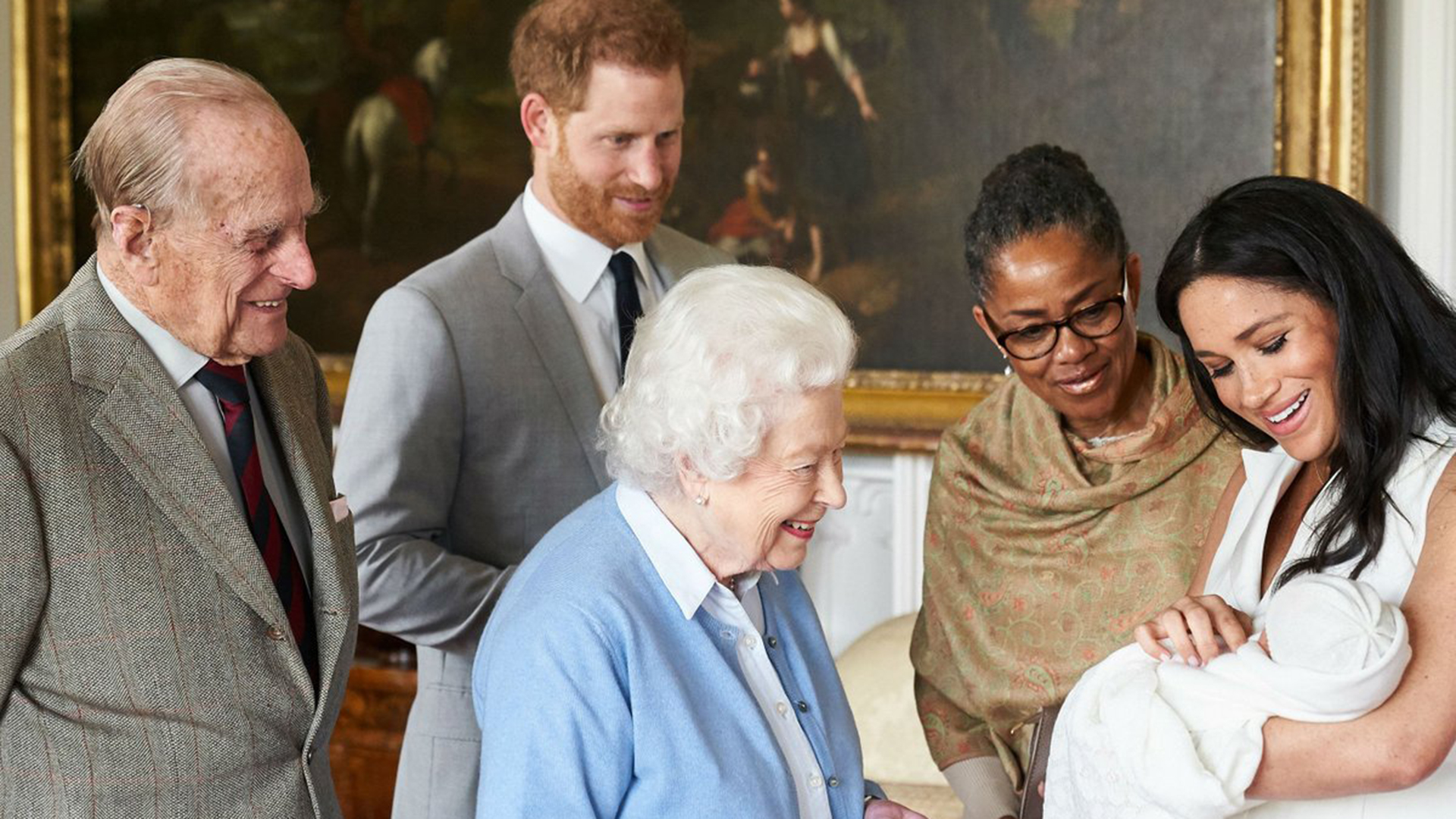 La reina Isabel II, Felipe de Edimburgo y la madre de Meghan Markle mirando a Archie Harrison Mountbatten-Windsor, hijo de los duques de Sussex
