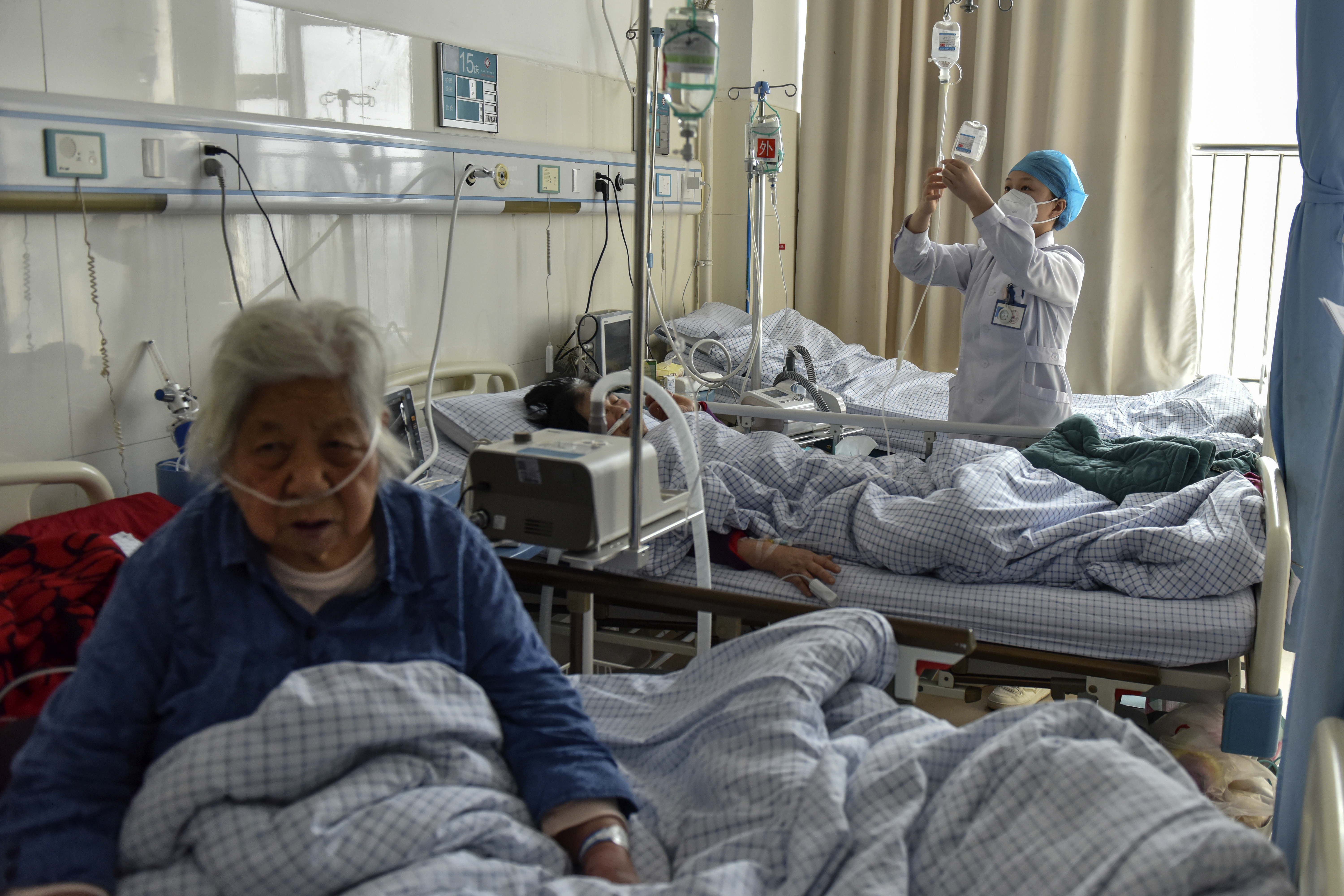 Pacientes ancianos con síntomas de COVID reciben sueros intravenosos en la sala de urgencias de un hospital de Fuyang, en la provincia central china de Anhui, el 4 de enero de 2023. Chinatopix vía AP/Archivo
