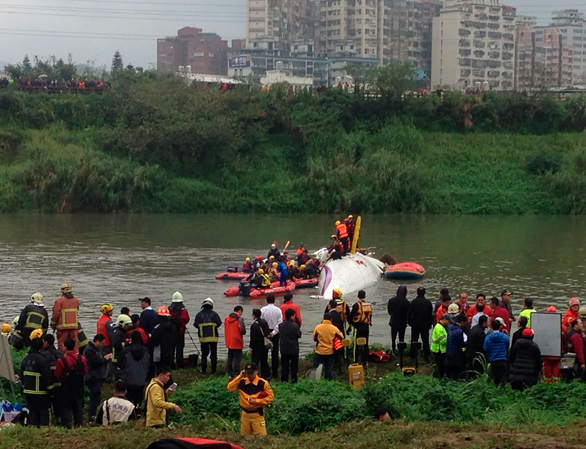 Rescatistas buscan sobrevivientes entre los restos del avión de TransAsia en el río Keelung. (Getty Images)