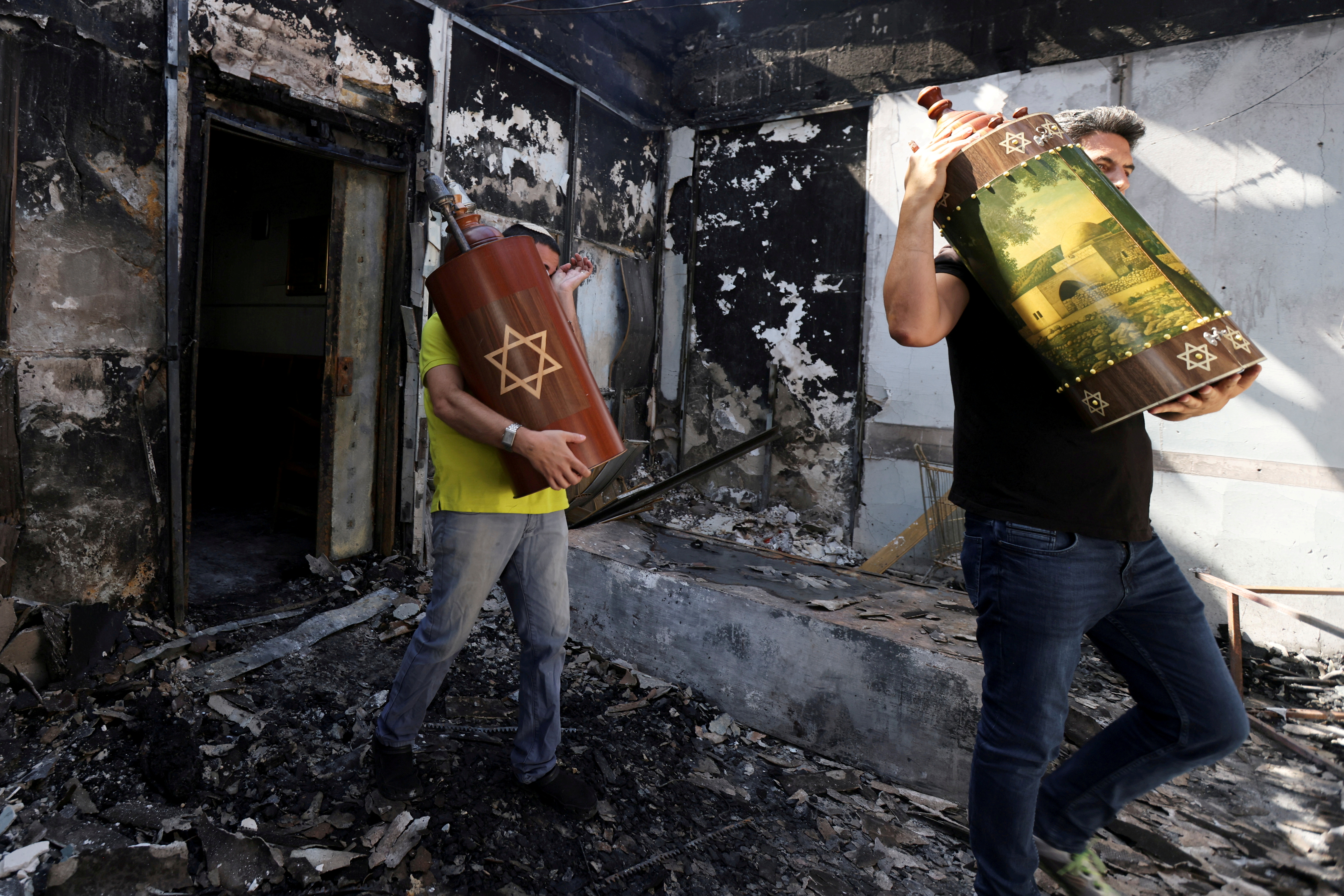 Rescate de los rollos de la Torah y las escrituras sagradas de una sinagoga incendiada durante los enfrentamientos entre ciudadanos árabes y judíos en la ciudad israelí de Lod. REUTERS/Ronen Zvulun/File Photo
