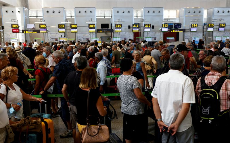 FOTO DE ARCHIVO: Viajeros haciendo fila frente a los mostradores de facturación del aeropuerto de Málaga-Costa del Sol en Málaga, Andalucía, España, el 4 de junio de 2022. REUTERS/Jon Nazca