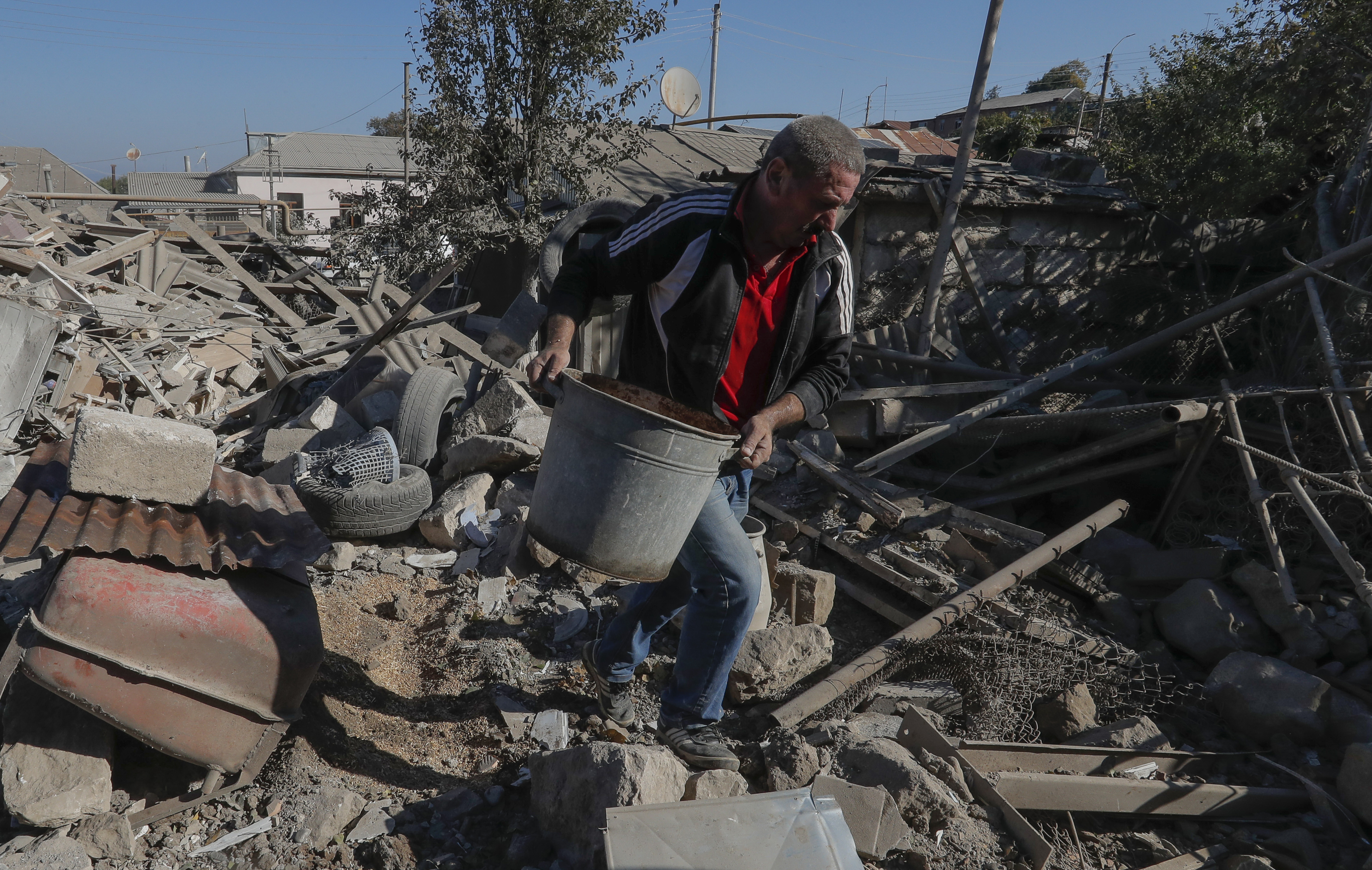 Un hombre revuelve escombros de un edificio destruido por un bombardeo en Nagorno Karabj. REUTERS/Stringer