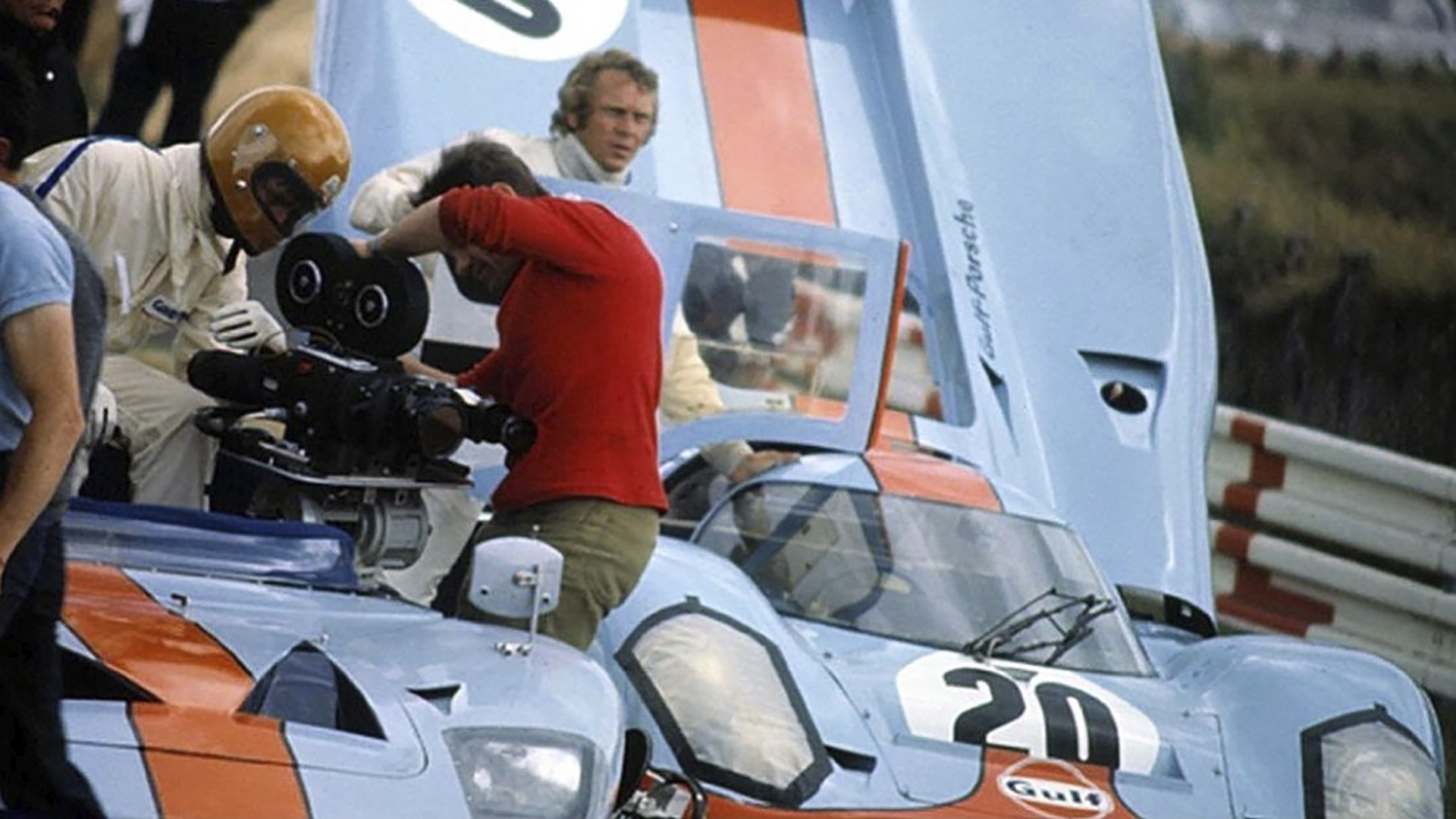 En primer plano, el Ford GT40 usado para correr con una cámara a la par de los Porsche 917. Detrás, Steve McQueen, protagonista de la película "Le Mans"