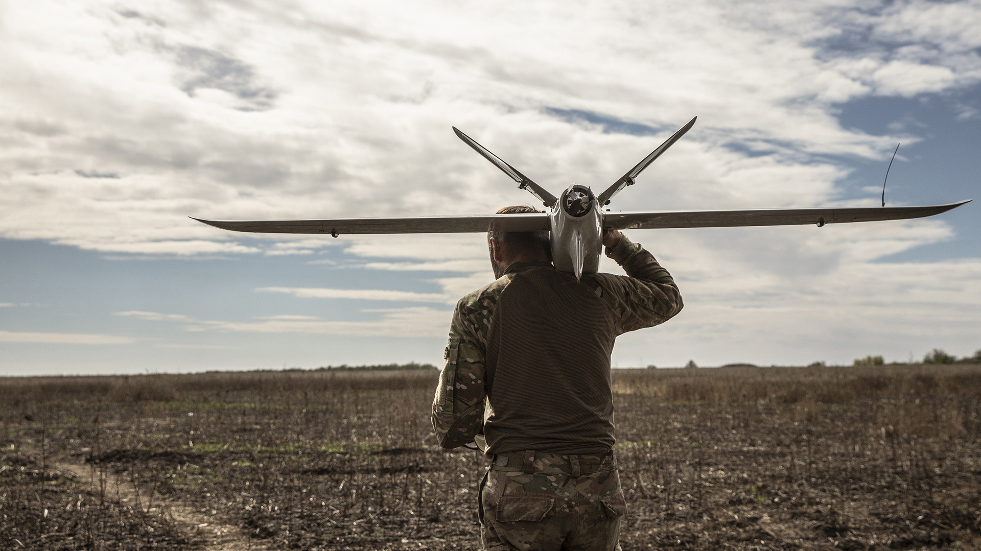 Un soldado ucraniano que se hace llamar "Viter" lleva un dron Leleka-100 a punto de ser lanzado, y navega cuidadosamente por un campo el jueves en la región de Kherson, Ucrania, sembrado de minas rusas. (Foto para The Washington Post por Heidi Levine)