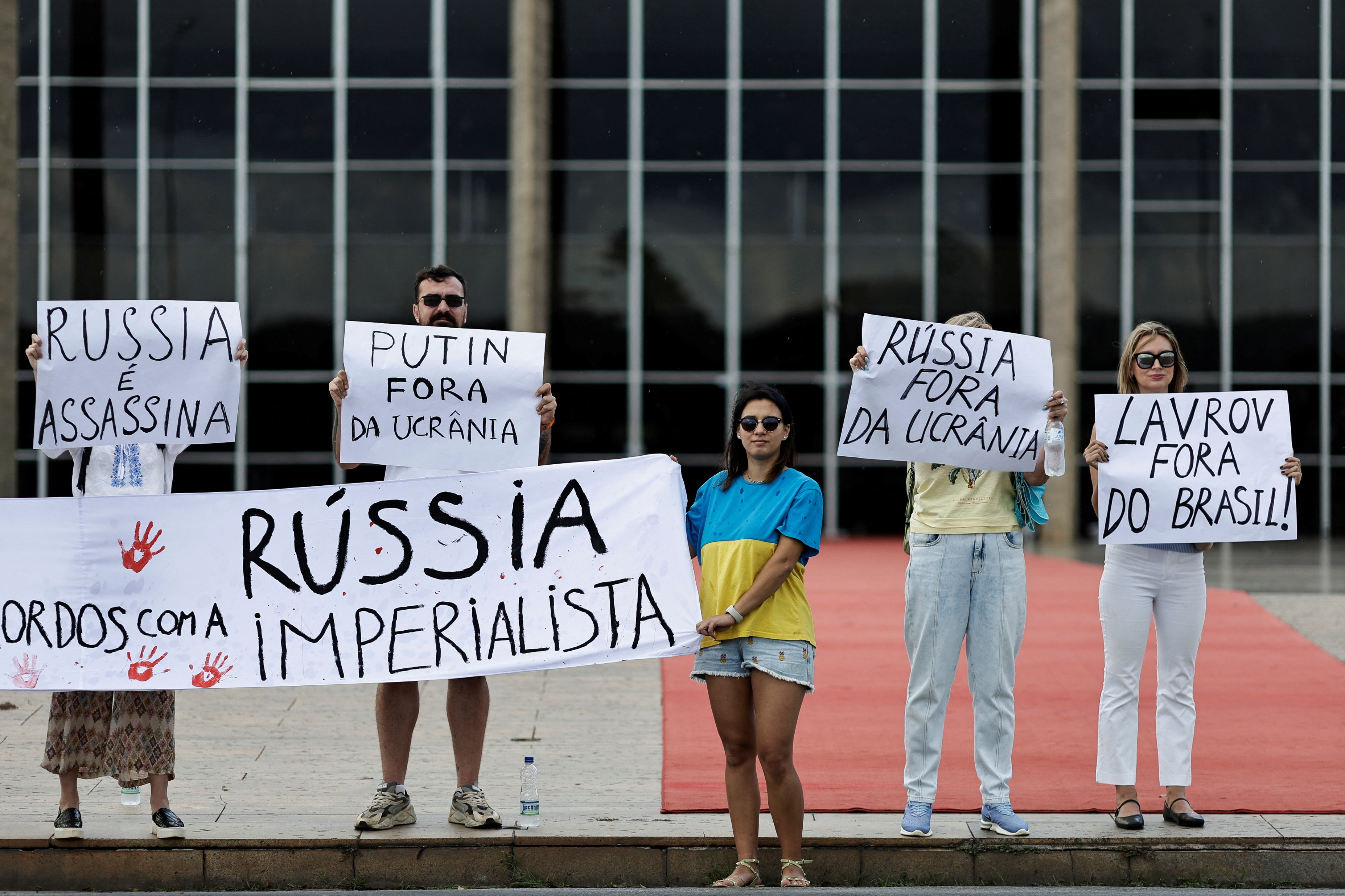 People hold signs as they protest against Russia's Foreign Minister Sergei Lavrov visit to Brazil and to support Ukraine in Brasilia, Brazil, April 17, 2023. REUTERS/Ueslei Marcelino