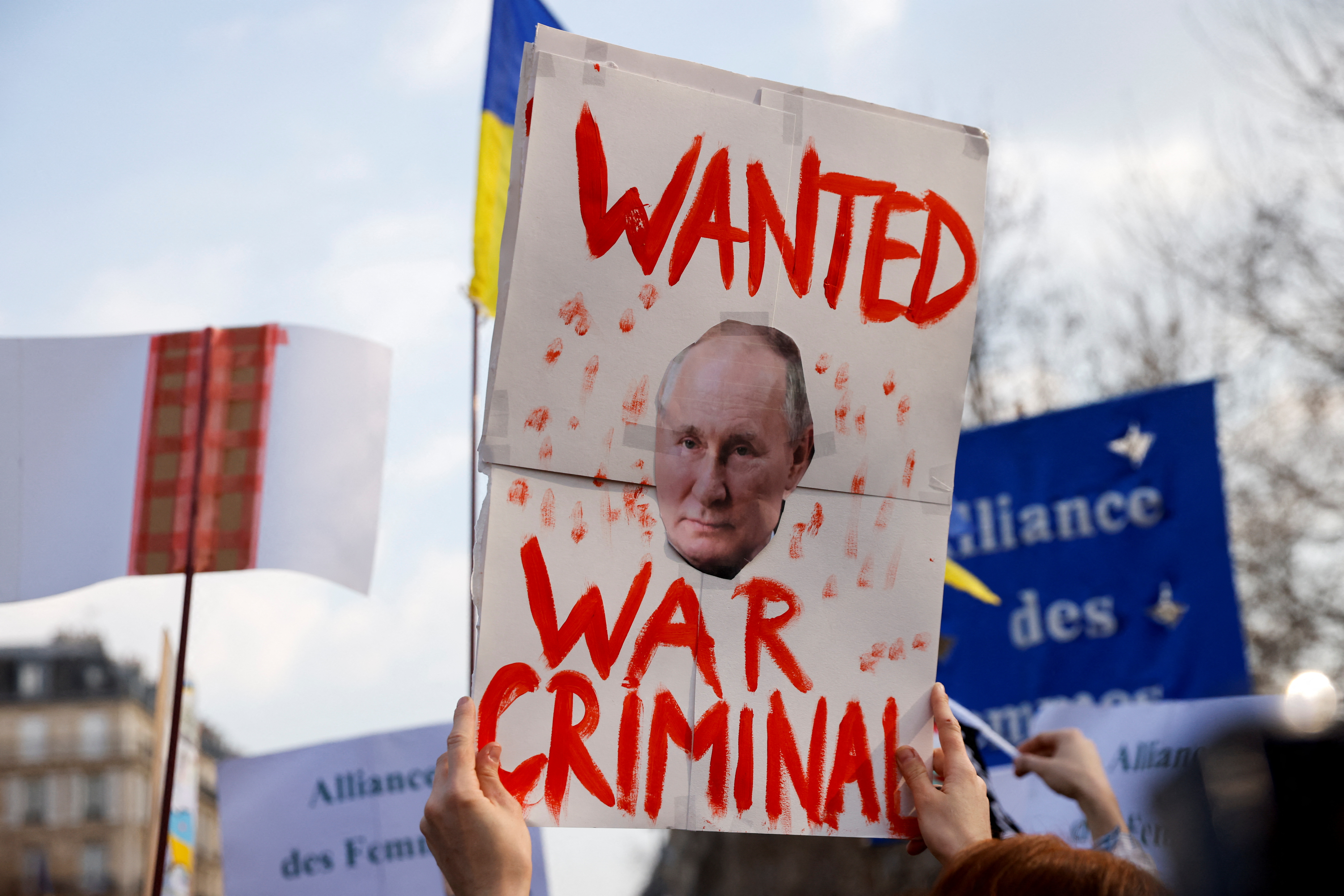 Carteles en contra de la invasión rusa a Ucrania y que señalan al jefe de estado ruso Vladimir Putin como un criminal de guerra pueden verse durante una protesta en las calles de París este 5 de marzo (Reuters)