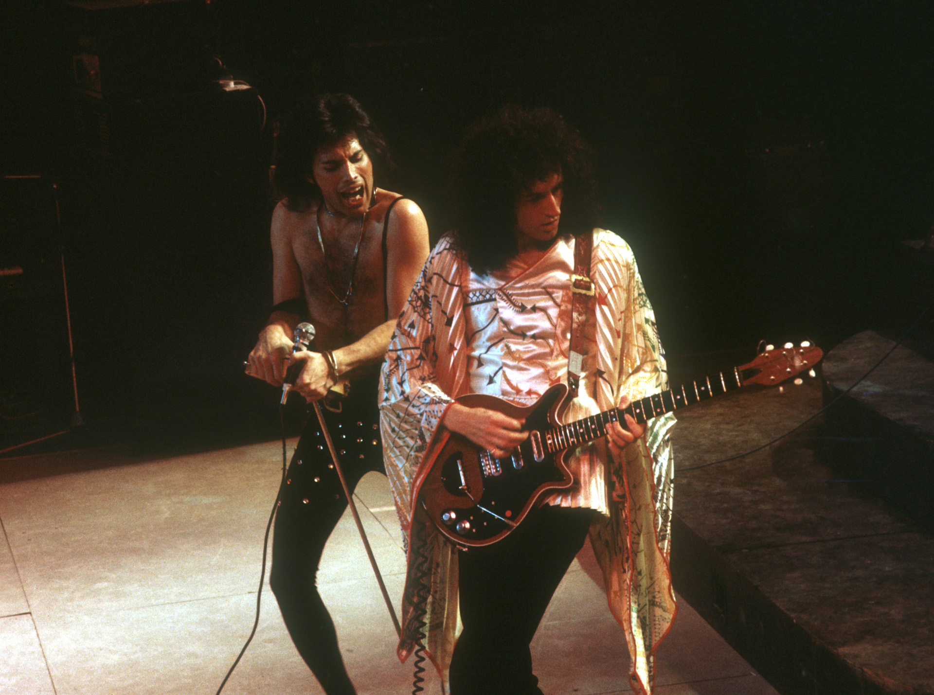 Brian May junto a Freddie Mercury tocando con Queen. Foto por Michael Ochs Archives/Getty Images