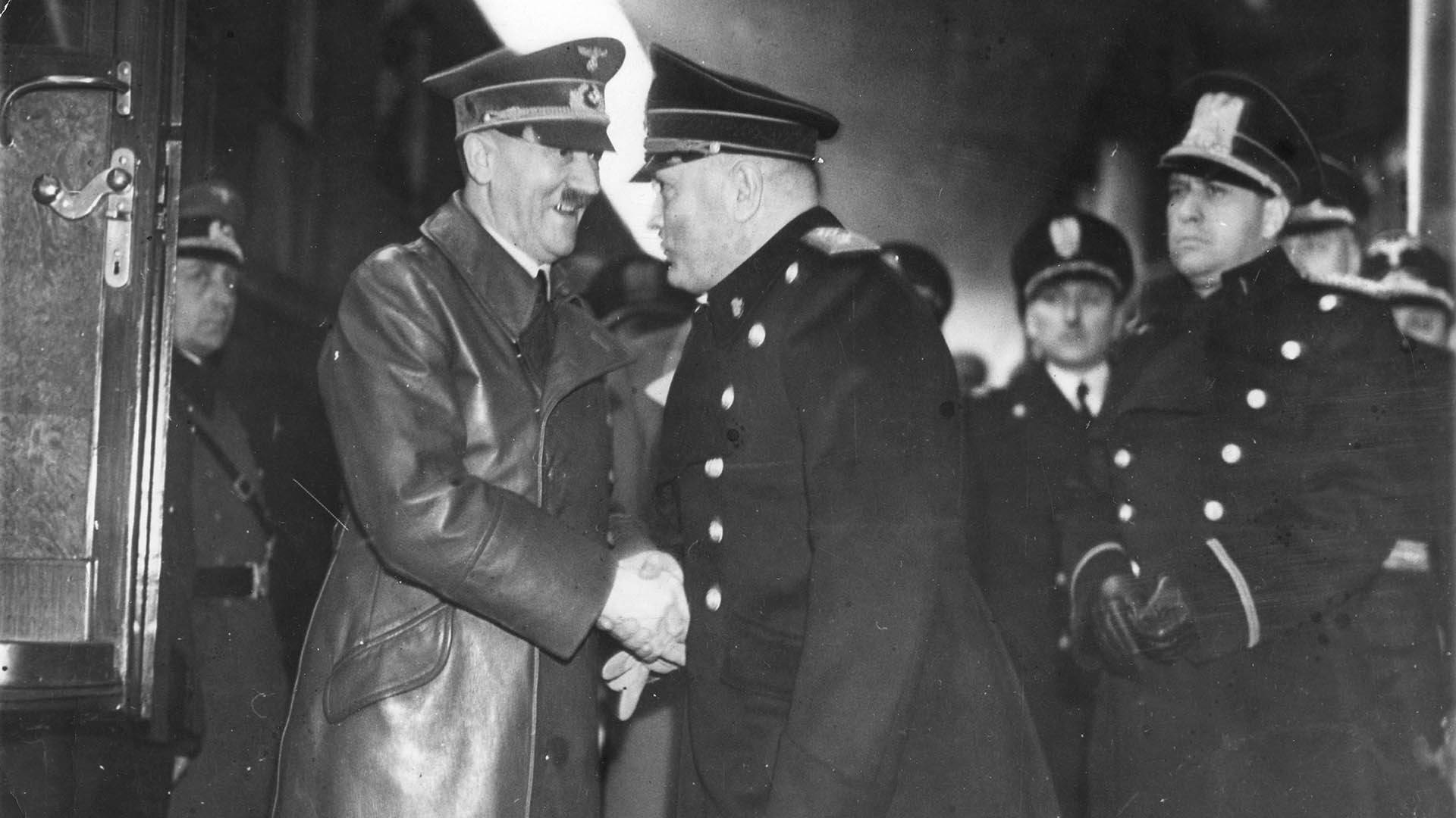 Adolf Hitler, con una amplia sonrisa, le da un firme apretón de manos a Benito Mussolini, durante una reunión para discutir la guerra, celebrada en la estación de tren Brennero, marzo de 1940 (Quest/Getty Images)
