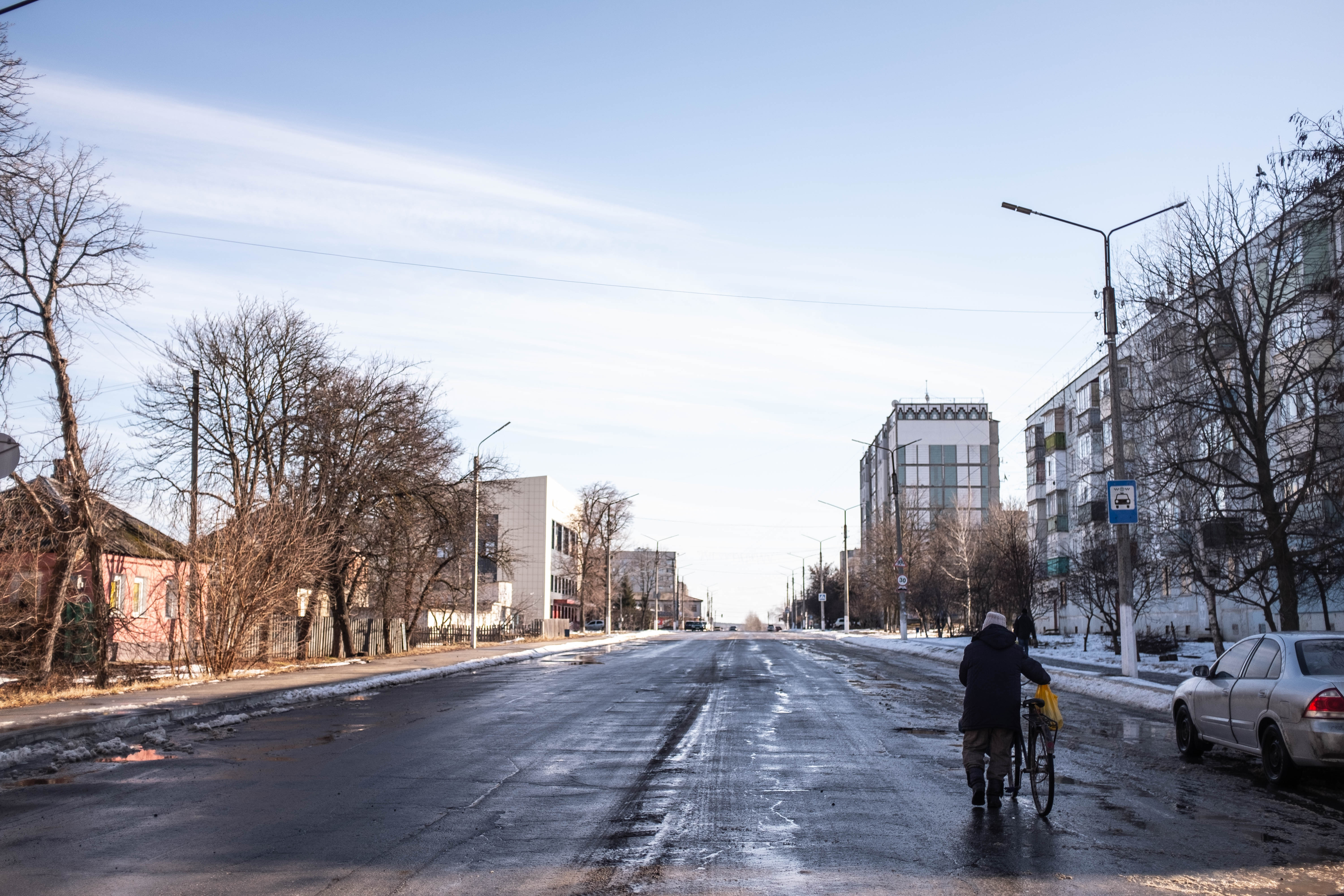 Una mujer camina junto a su bicicleta en la ciudad de Balakliya en el Oblast de Kharkiv, luego de que esta fuera recuperada por el Ejército Ucraniano.