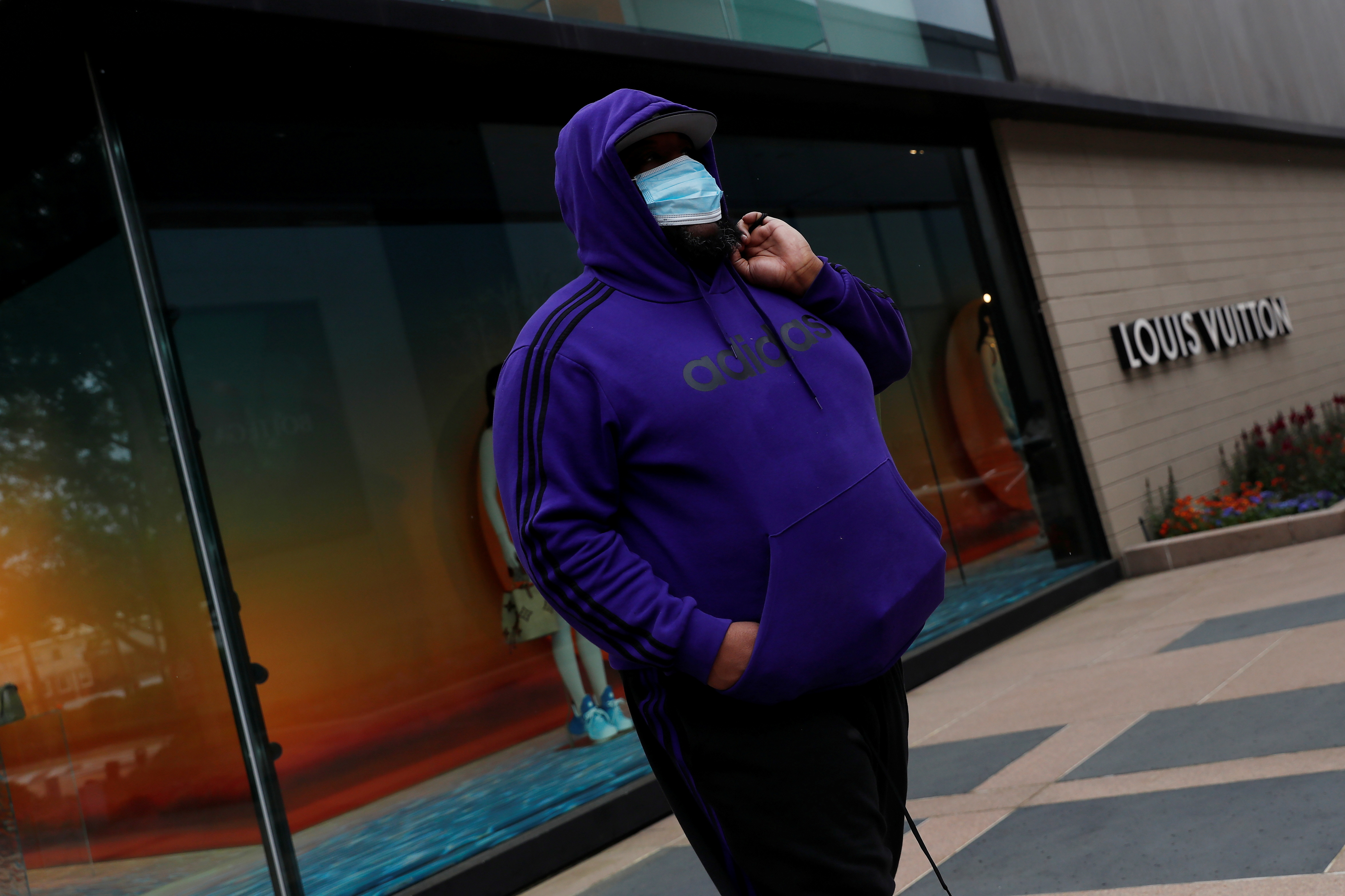 Un hombre usando una mascarilla afuera de un local de Louis Vuitton luxury en Manhasset, Nueva York. REUTERS/Shannon Stapleton