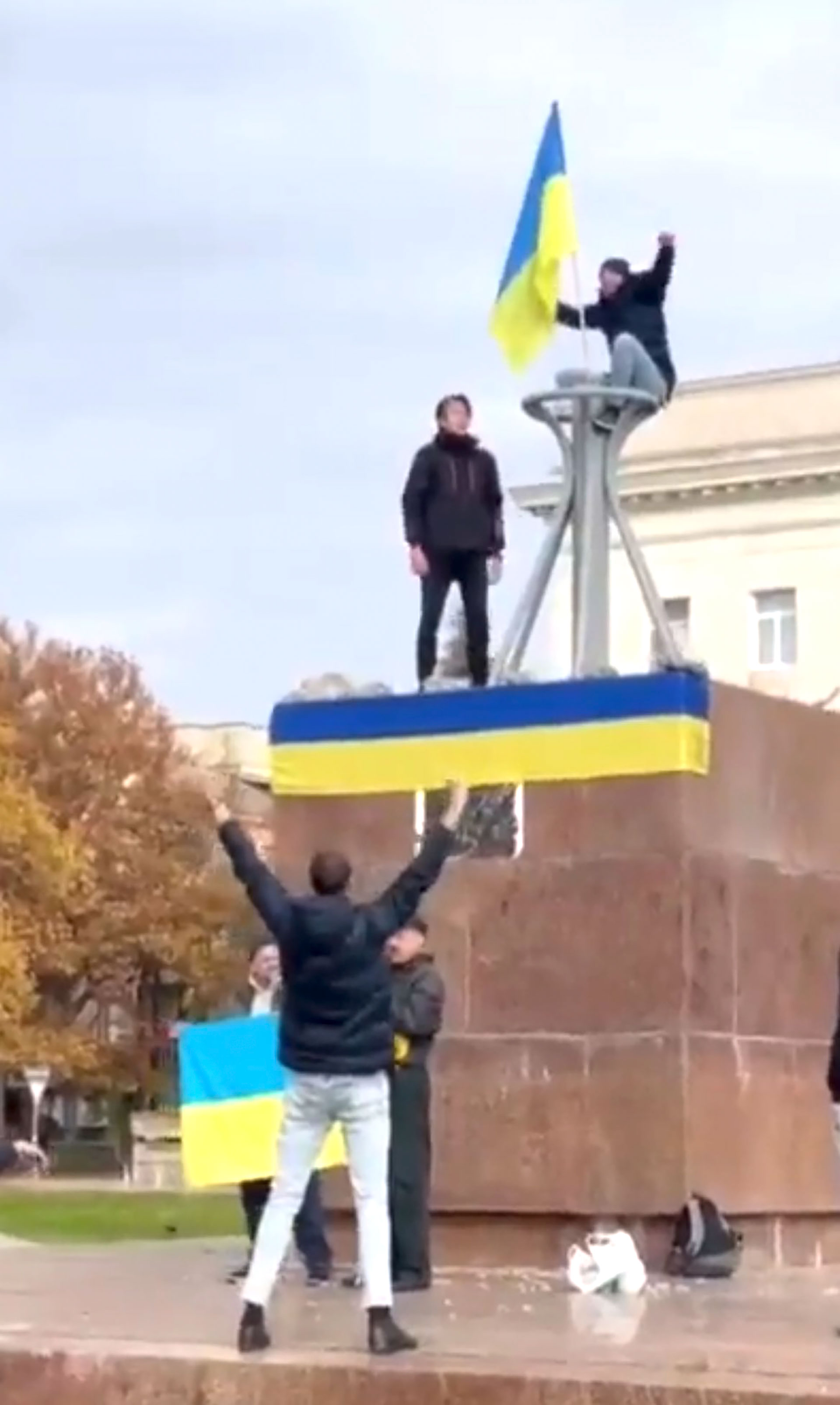 Chicos de Kherson enarbolando la bandera ucraniana en la plaza de Svobody, en la recuperada ciudad de Kherson, que estuvo en manos de los invasores rusos por nueve meses. (@WarMonitor3)