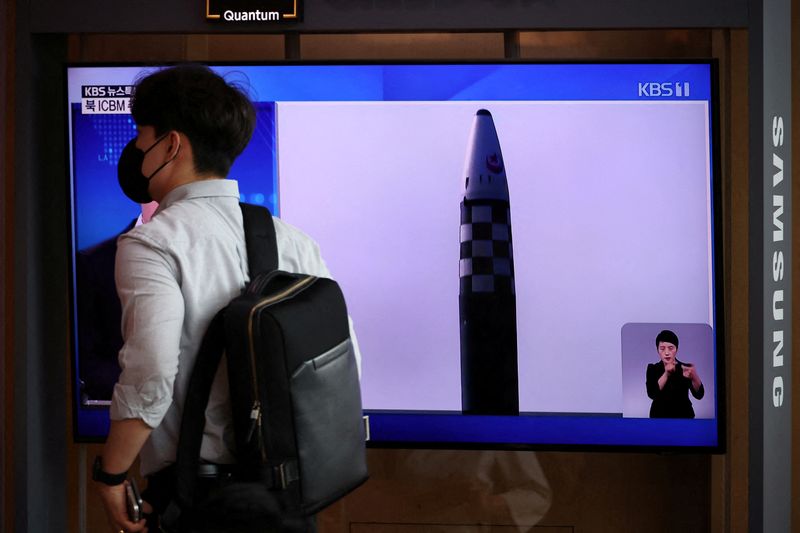 Un hombre pasa frente a un televisor que transmite un informe de noticias sobre el lanzamiento de tres misiles por parte de Corea del Norte