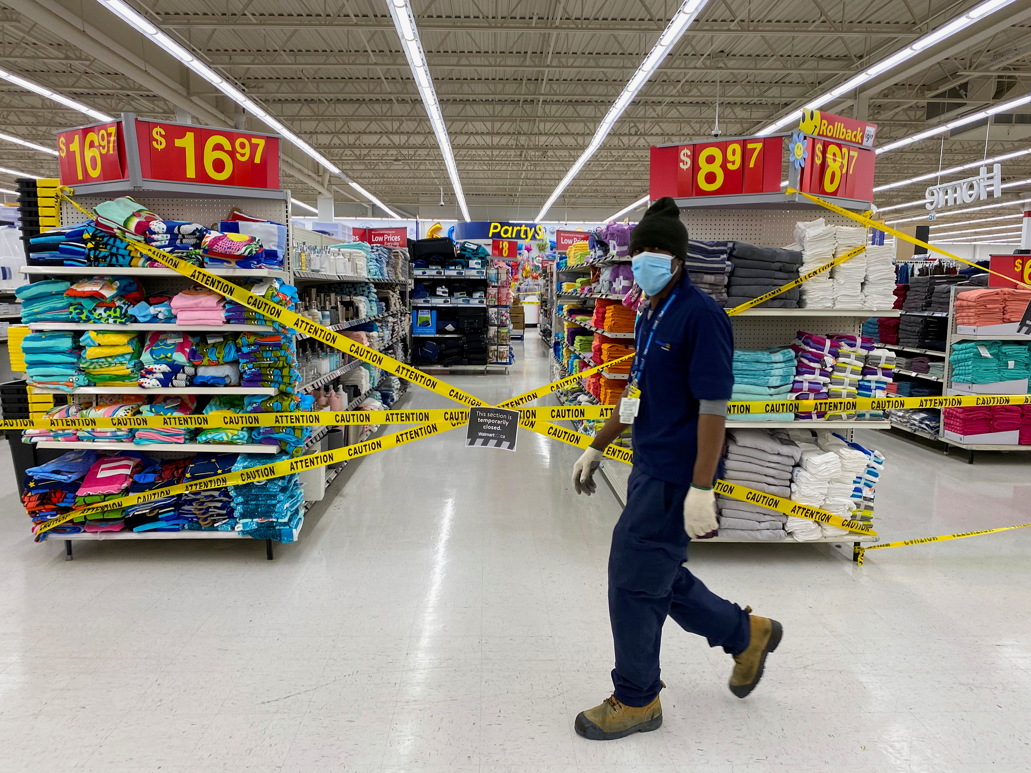 Un empleado de Walmart camino junto a los productos marcados como "no esenciales" en medio de la cuarentena (REUTERS/Carlos Osorio)