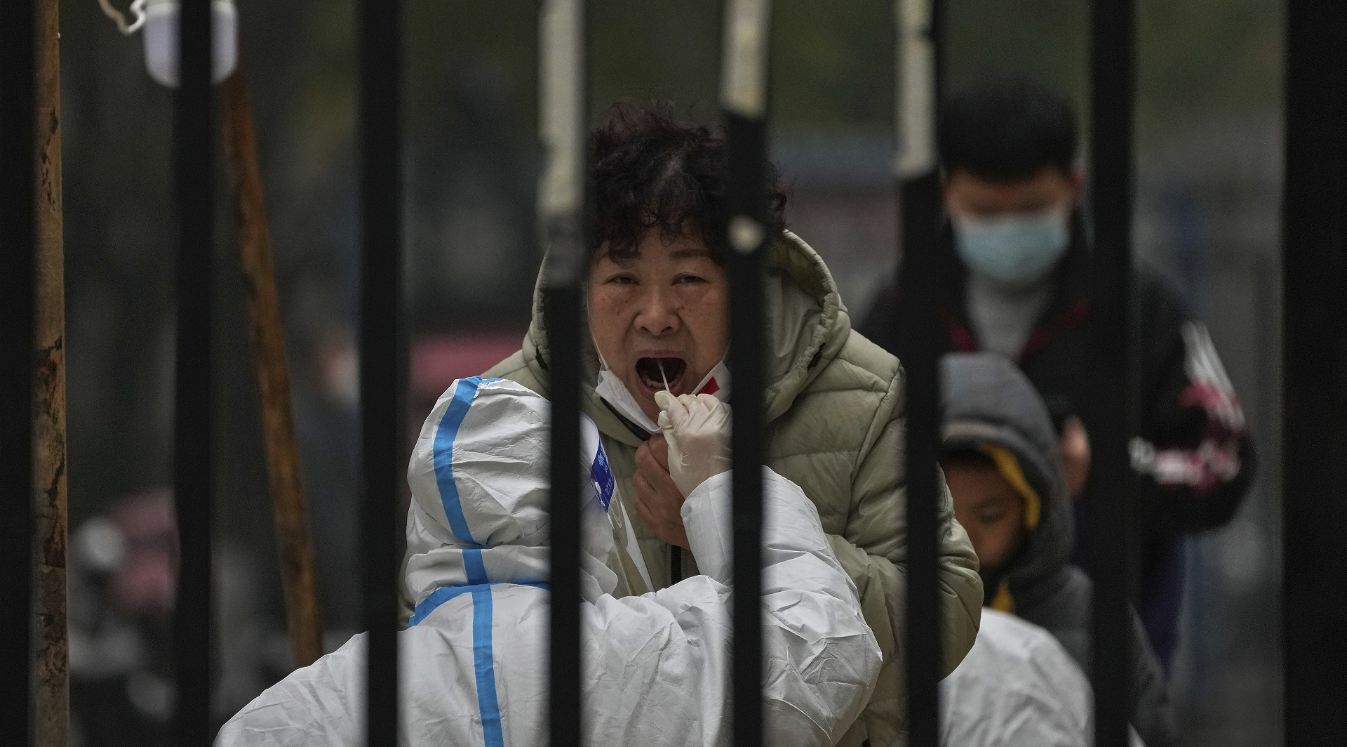 Una mujer pasa por un hisopado en una zona residencial de Beijing (AP)