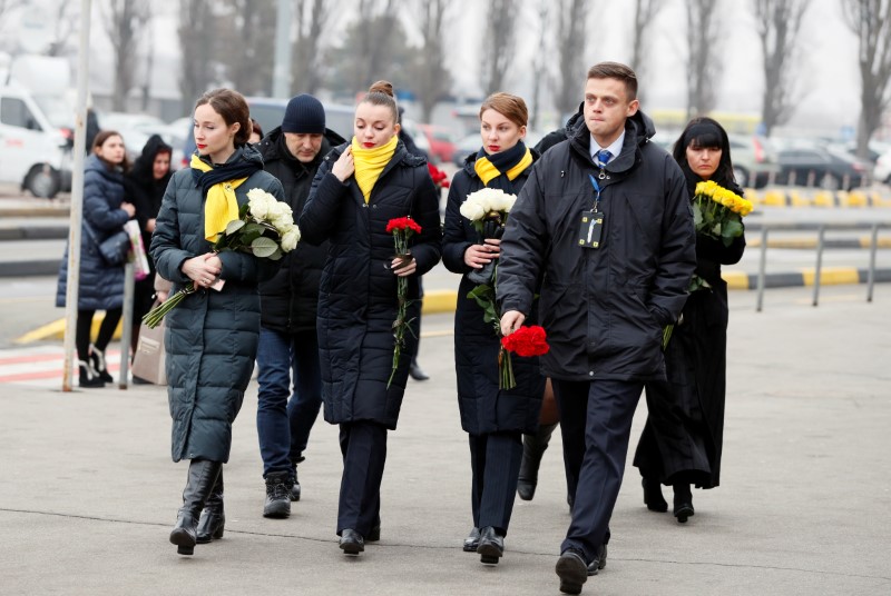 Los miembros de la tripulación de Ukraine International Airlines llegan para la ceremonia de traslado de las víctimas del vuelo 752