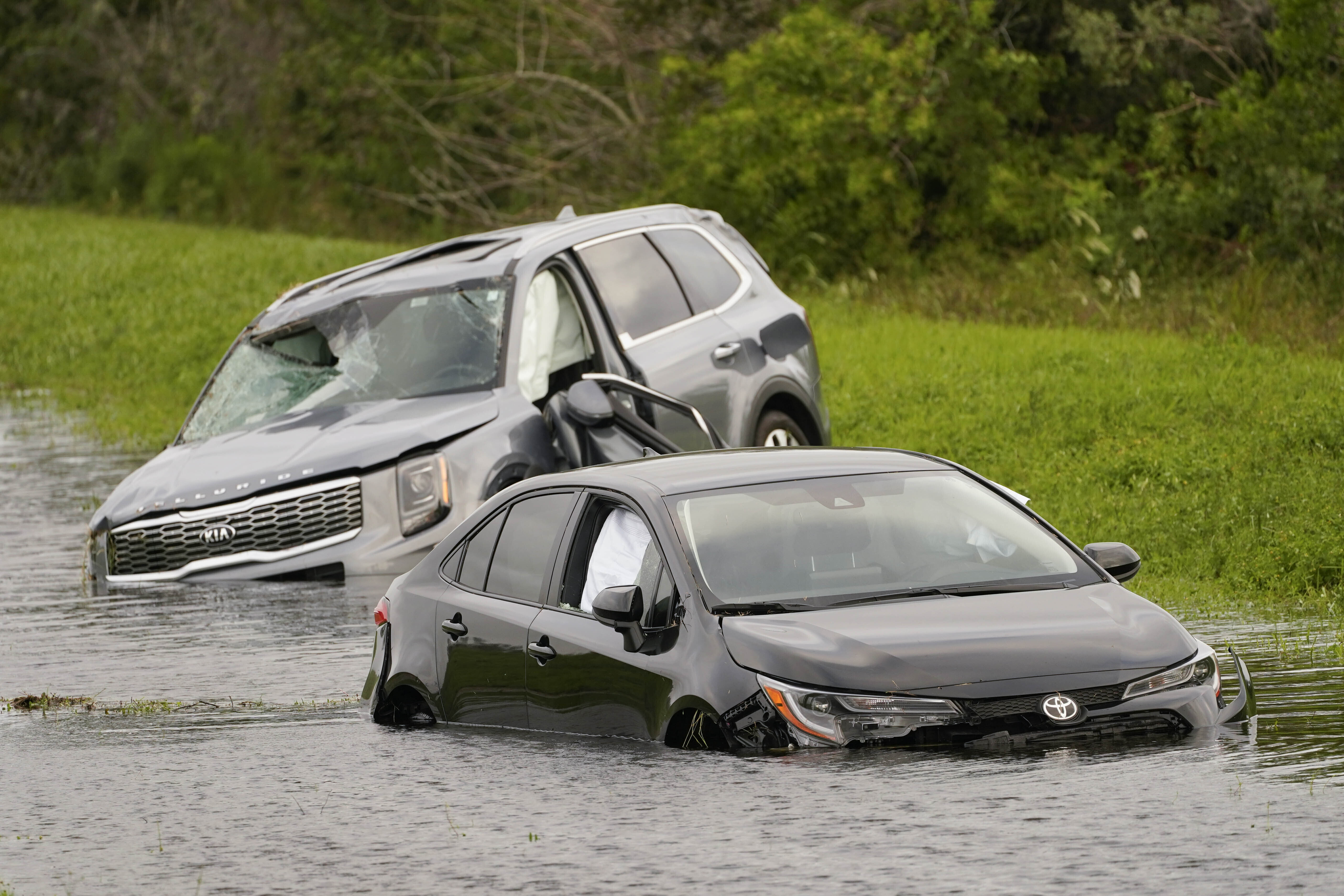 Dos vehículos se encuentran en las aguas de la inundación al costado de la Interestatal 75 en North Port, Florida, luego del huracán Ian, el jueves 29 de septiembre de 2022. (AP Photo/Steve Helber)