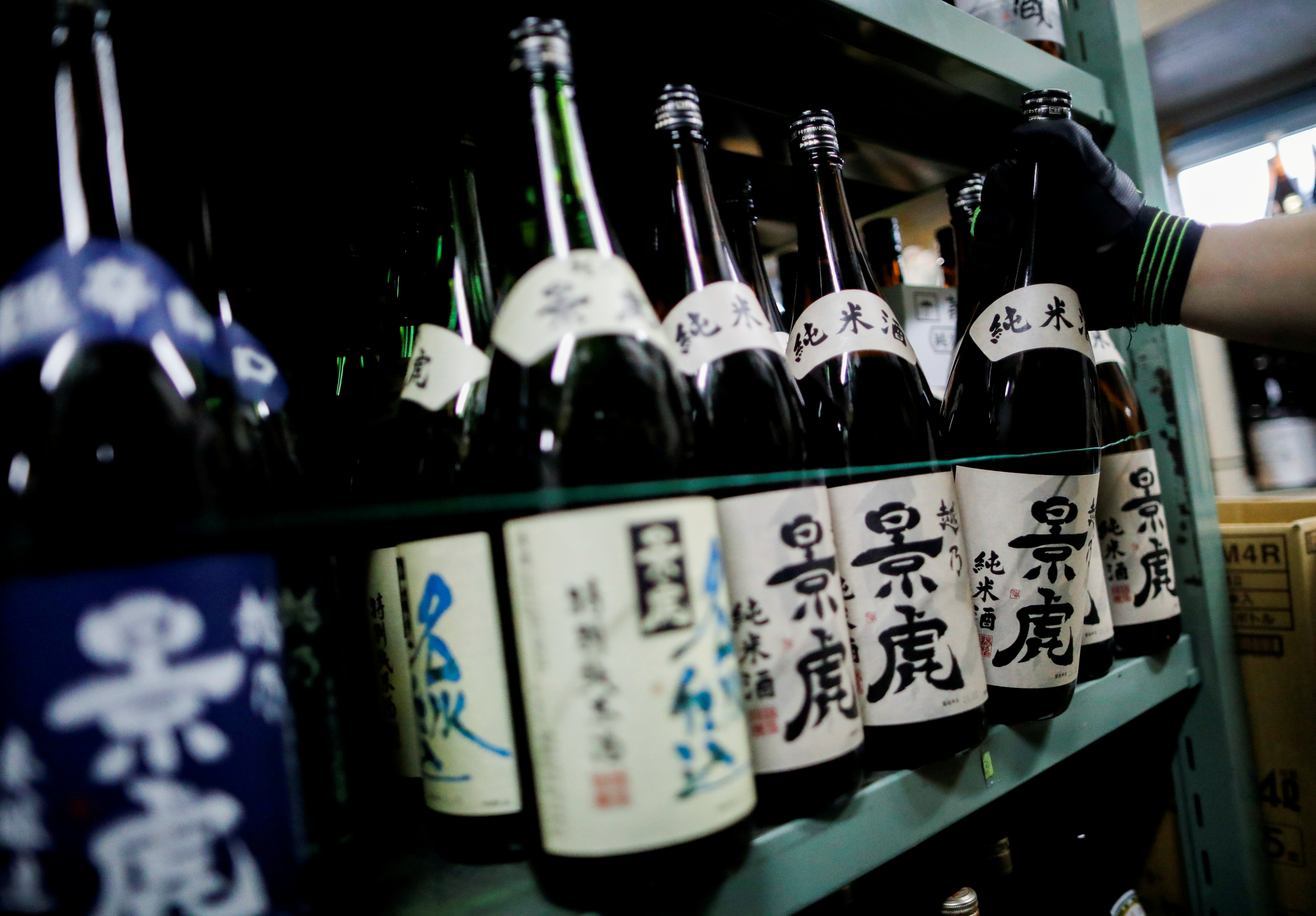Un empleado de Sasaki Saketen, una empresa mayorista de licores, se dedica al trabajo de envío de botellas de sake (REUTERS/Issei Kato/archivo)

