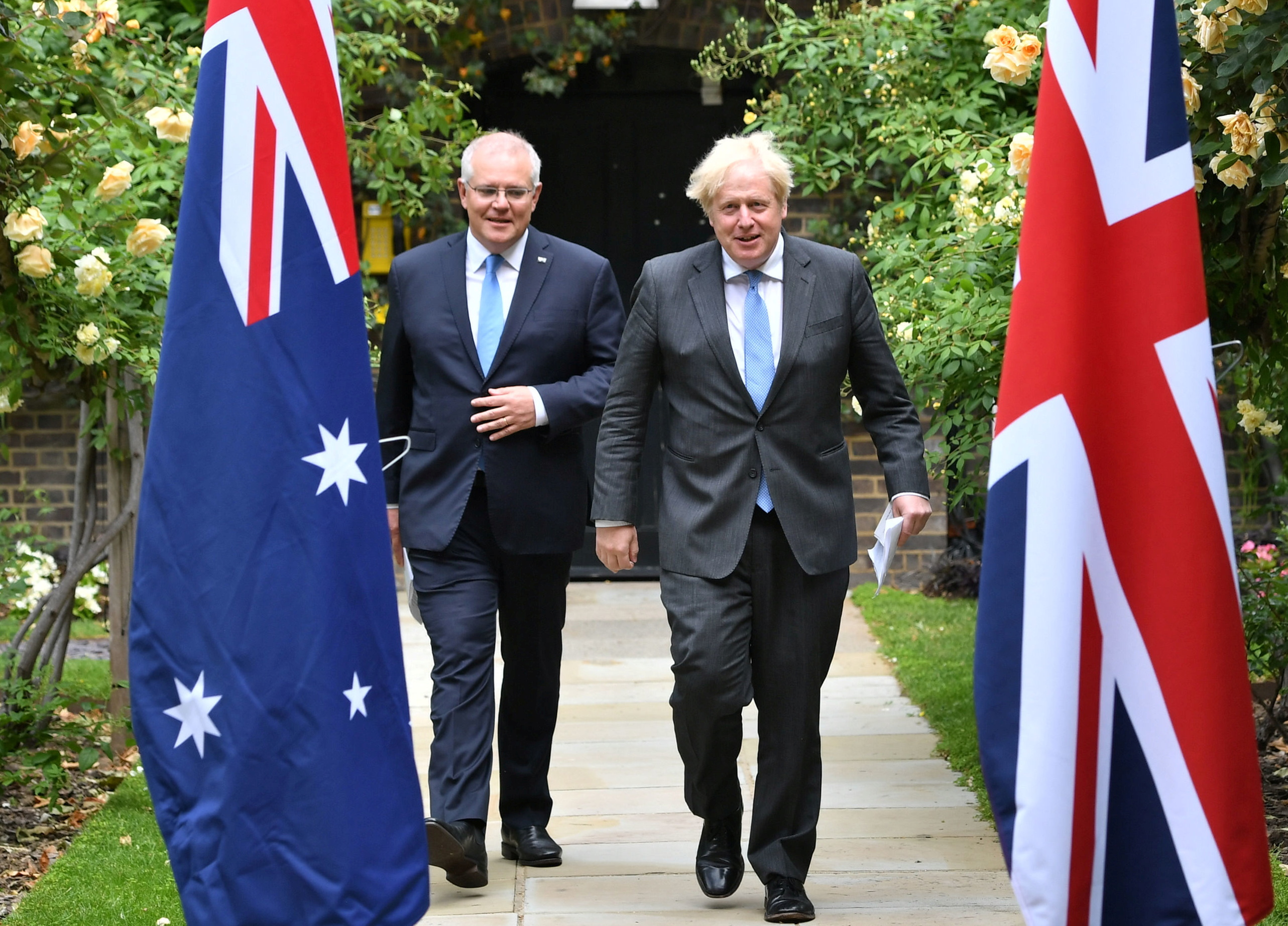 El primer ministro británico, Boris Johnson, y su homólogo australiano, Scott Morrison, caminan por el jardín del número 10 de Downing Street en Londres, Reino Unido, el 15 de junio de 2021. Dominic Lipinski / Pool a través de REUTERS