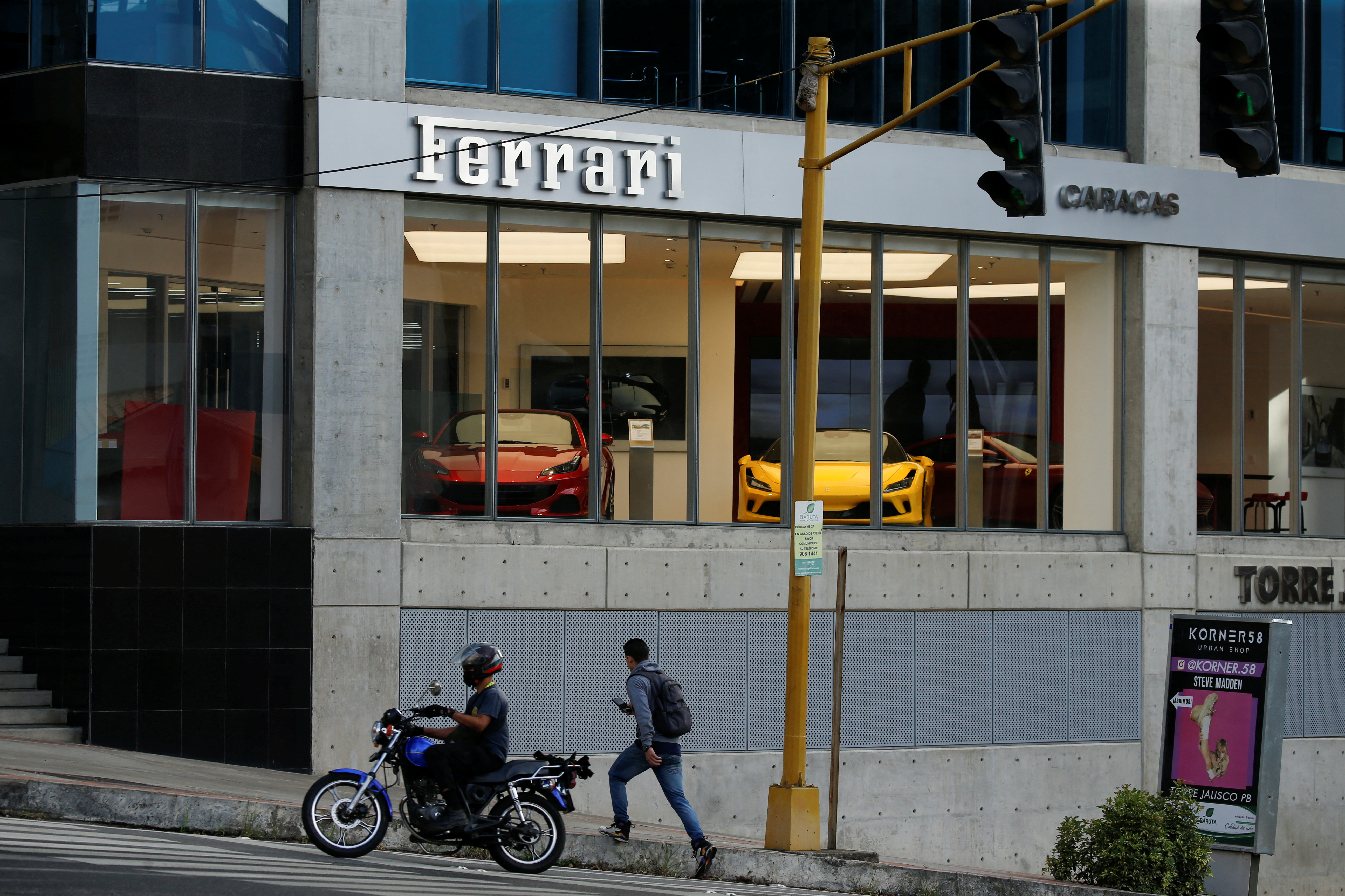Un hombre cruza la calle frente a un concesionario Ferrari en Caracas, Venezuela (REUTERS/Leonardo Fernandez Viloria)