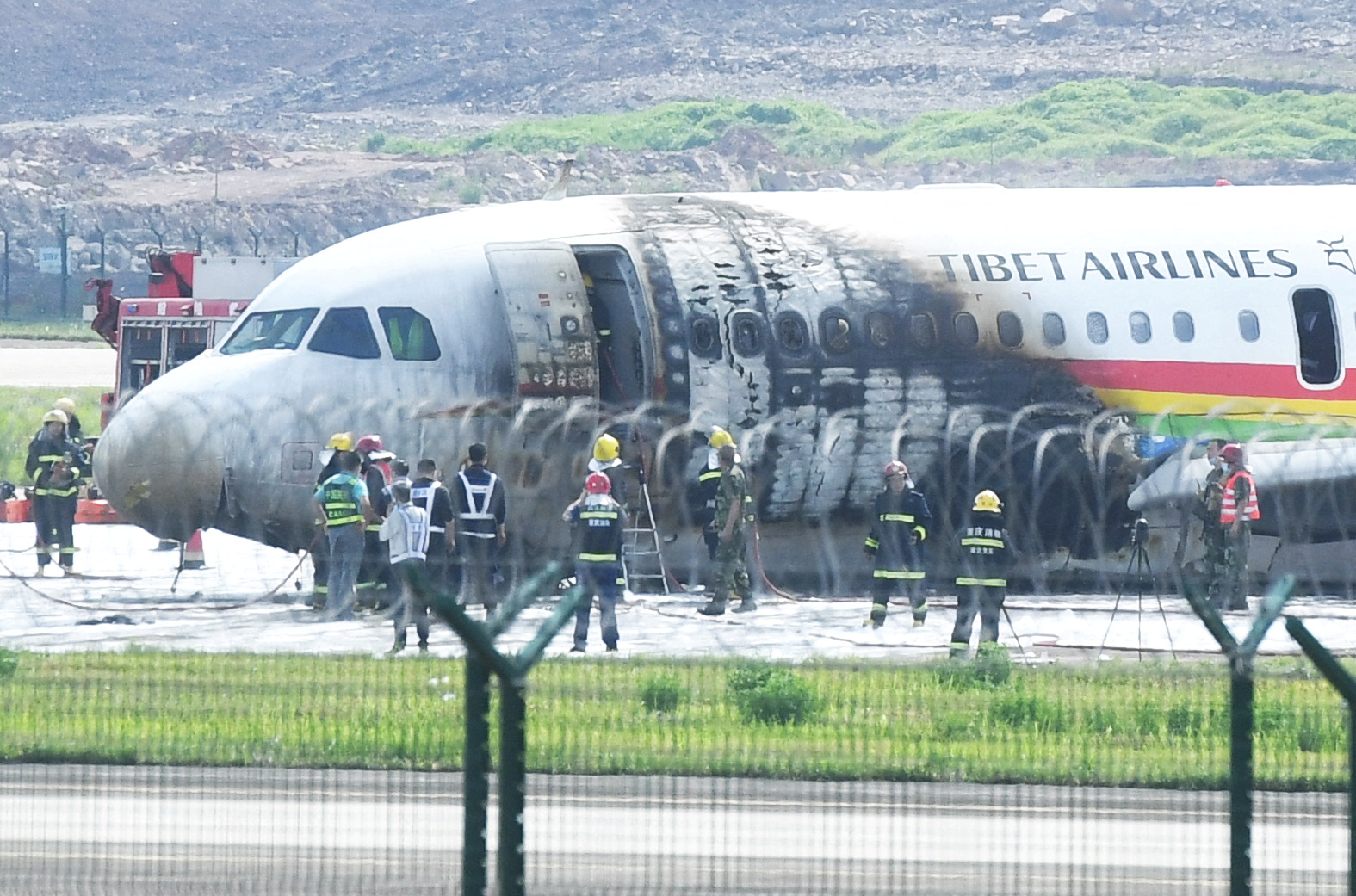 Los trabajadores de rescate son vistos en el lugar donde un avión Airbus A319 de Tibet Airlines se incendió después de un despegue abortado, en el aeropuerto internacional de Chongqing Jiangbei en Chongqing, China 12 de mayo de 2022. cnsphoto vía REUTERS