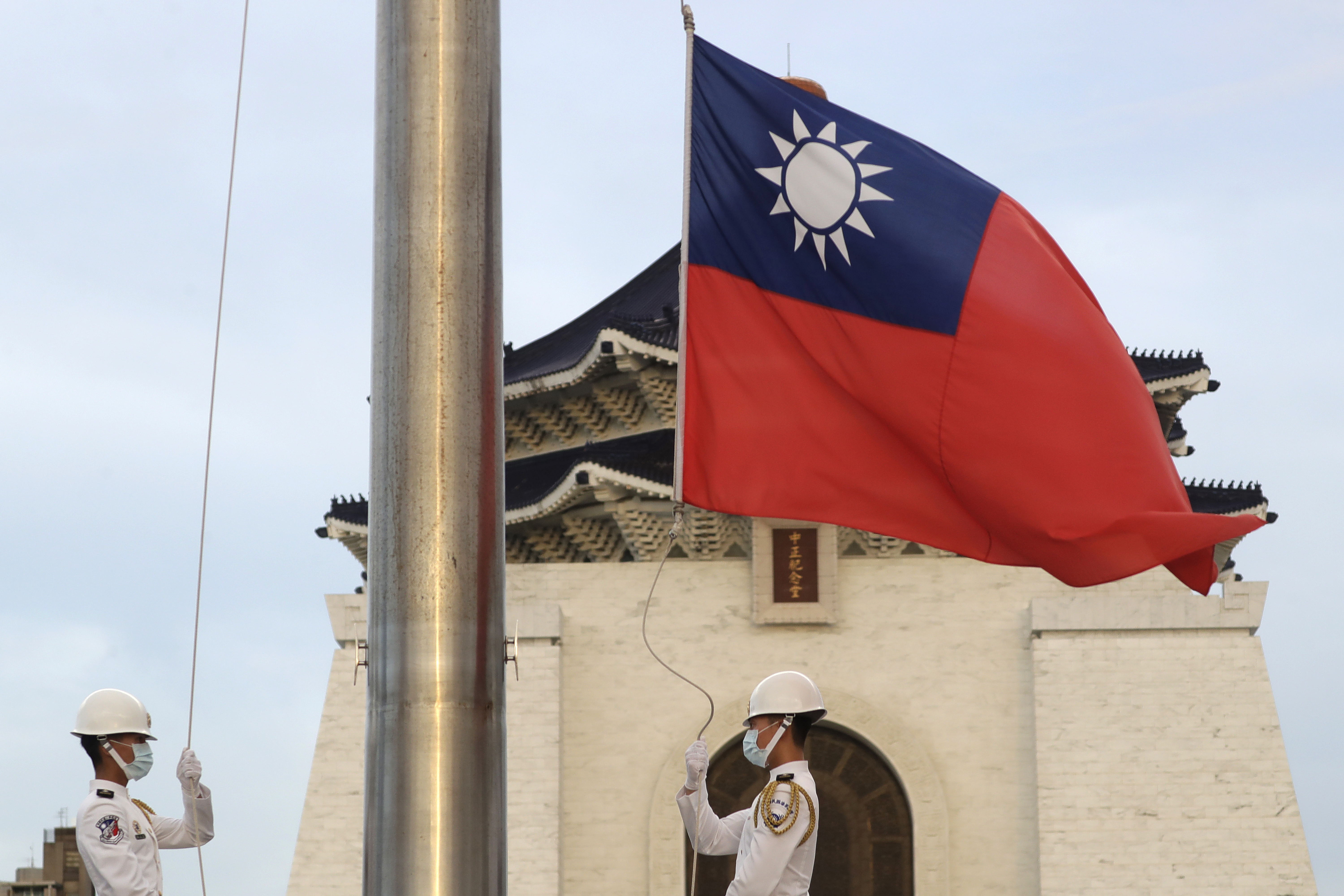 Soldados arrían la bandera nacional de Taiwán durante una ceremonia diaria en la Plaza de la Libertad, en Taipéi, Taiwán (AP Foto/Chiang Ying-ying, archivo)