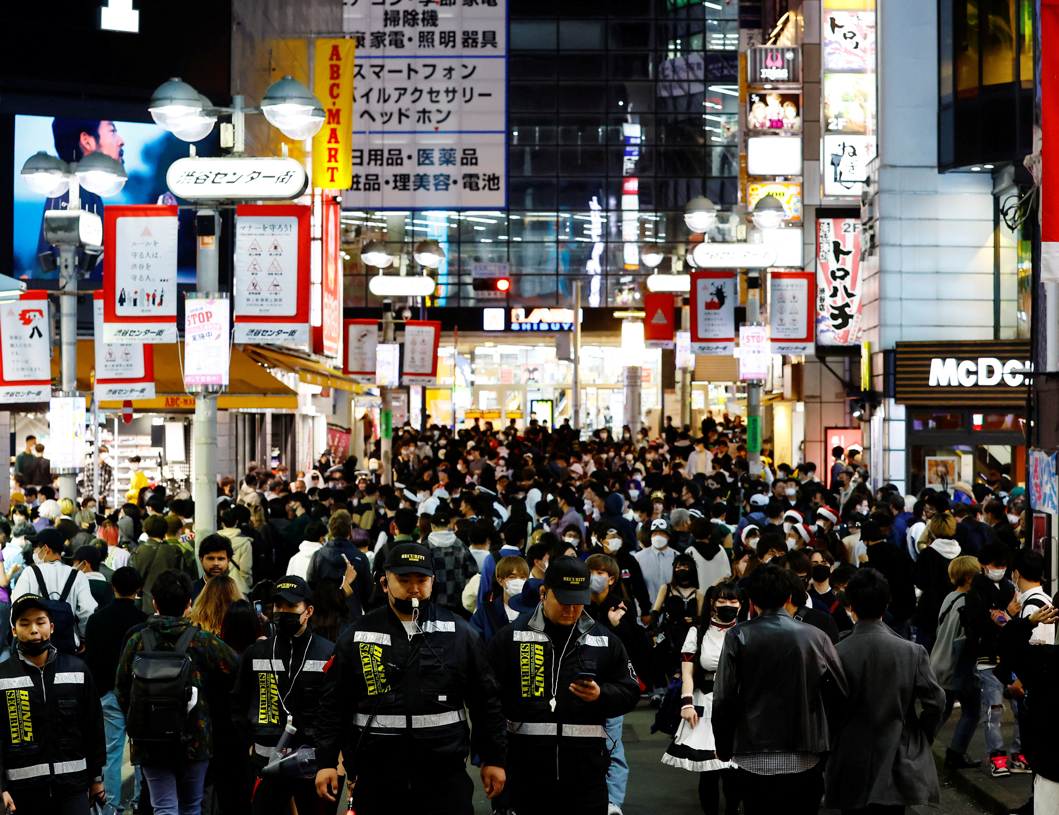 Security guards patrol to control crowds gathering to celebrate Halloween on the street at Tokyo's Shibuya entertainment and shopping district in Tokyo, Japan October 31, 2022. REUTERS/Kim Kyung-Hoon