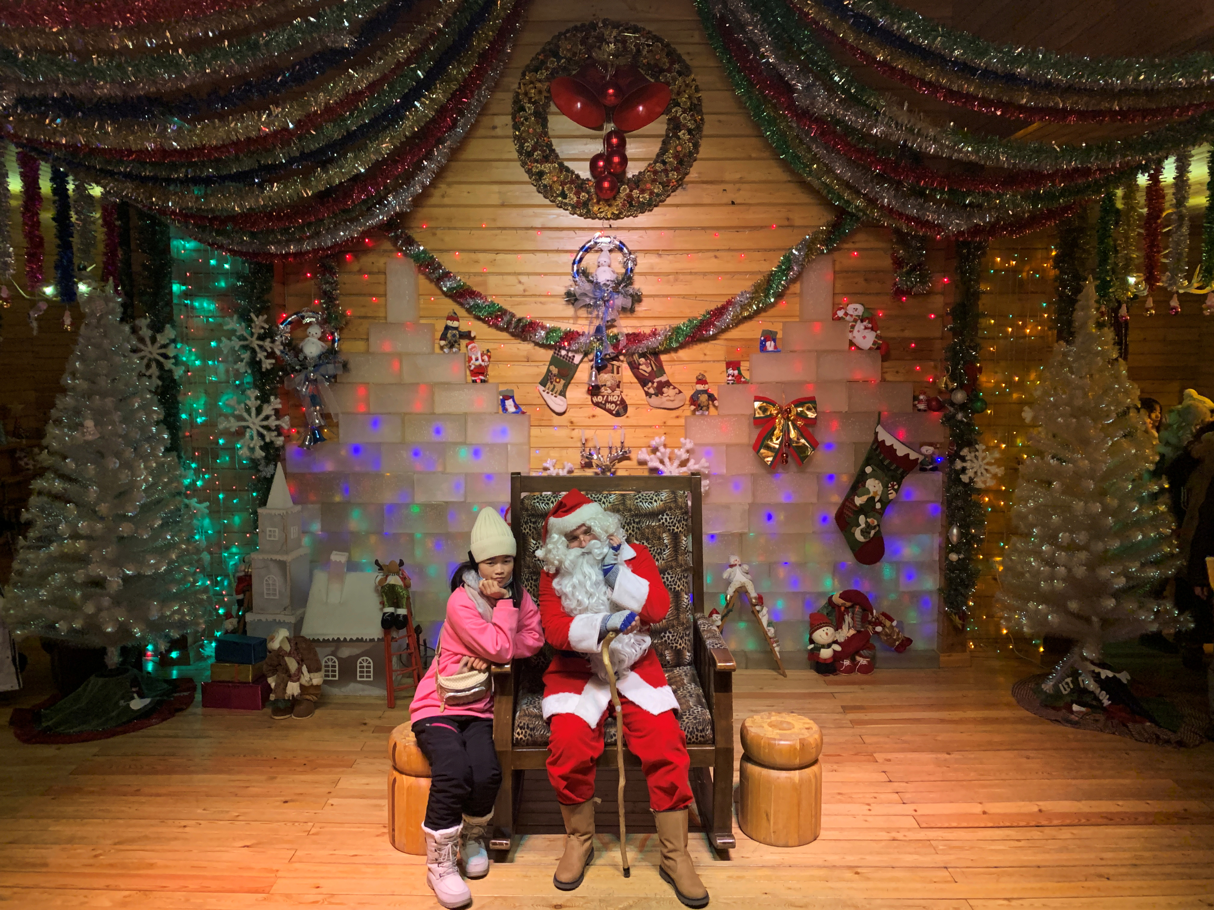 Un visitante posa con un Papá Noel, interpretado por Ville Haapassallo, de 35 años, de Finlandia, dentro de la Casa de Papá Noel en un parque temático de Navidad en las afueras de Mohe, la ciudad más septentrional de China, en la provincia de Heilongjiang (REUTERS/Xihao Jiang)