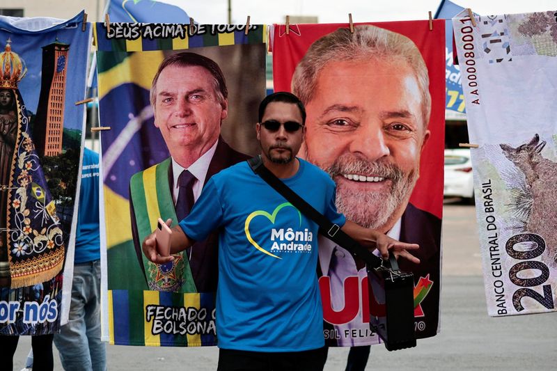 Imagen de archivo de un hombre parado frente a materiales de la campaña presidencial de Lula da Silva y Jair Bolsonaro en Brasilia (REUTERS/Ueslei Marcelino)