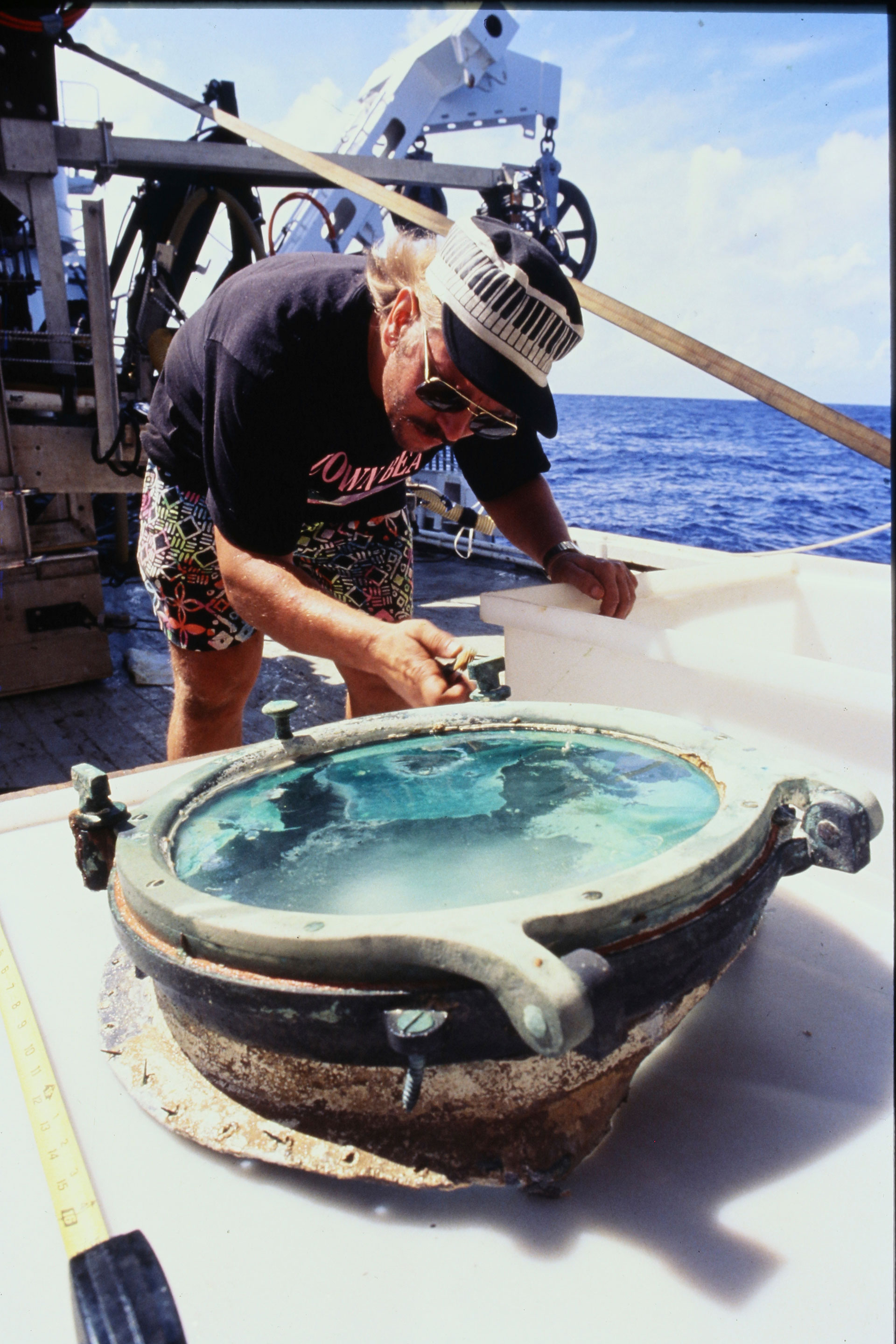 En esta foto de 1991 proporcionada por el científico del California Gold Marketing Group, Bob Evans, examina un ojo de buey recuperado del lecho marino del Océano Atlántico (California Gold Marketing Group a través de AP)