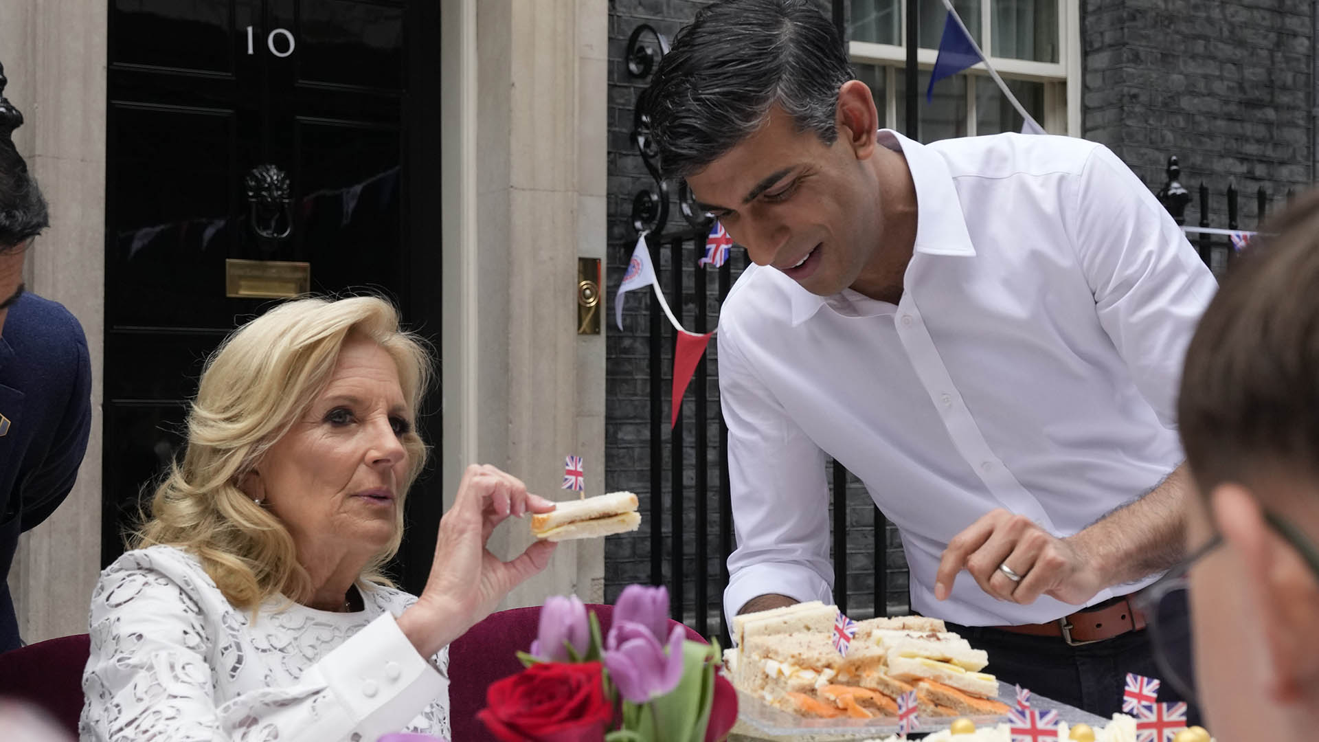El primer ministro Rishi Sunak sostiene un plato de sándwiches mientras la primera dama de EE. UU., Jill Biden, toma uno con una bandera británica mientras asisten a la fiesta Big Lunch en Downing Street en Londres. (Foto AP/Frank Augstein, Piscina)
