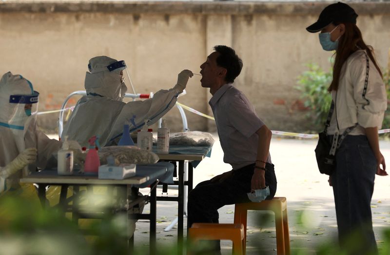 Un trabajador médico toma una muestra de hisopo de una persona para un test PCR en un centro de pruebas improvisado, en medio del brote de la enfermedad del coronavirus (COVID-19), en Pekín, China, el 23 de mayo de 2022. REUTERS/Tingshu Wang