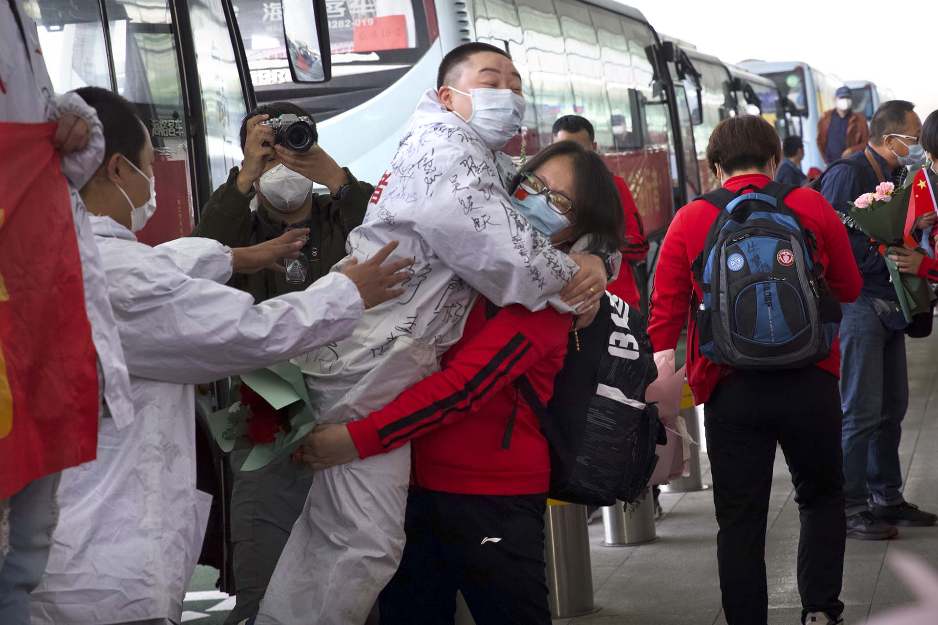 Un trabajador médico de la provincia china de Jilin abraza a un colega que se prepara para volver a su hogar en el Aeropuerto Internacional de Wuhan Tianhe (AP Photo/Ng Han Guan)