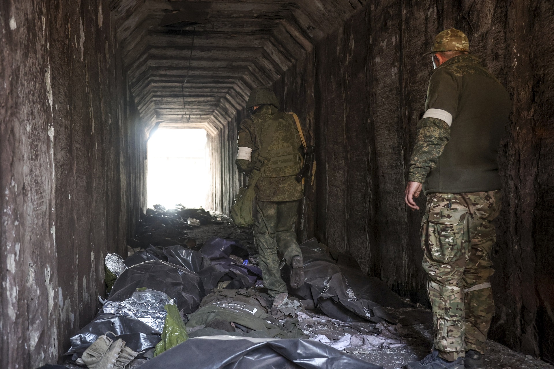 Milicia prorrusa observa las bolsas con cuerpos de soldados ucranianos en Mariupol (AP)