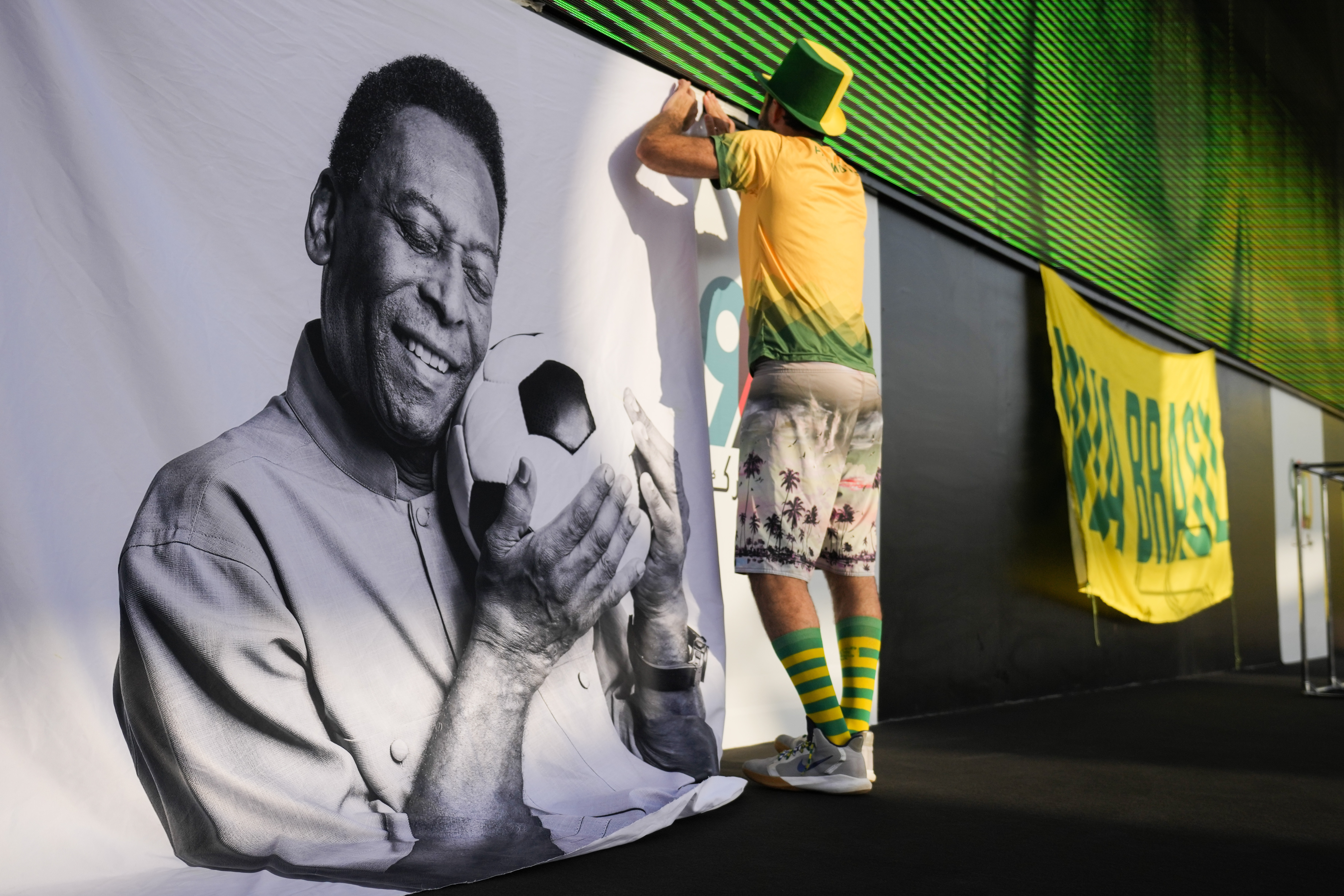 Un aficionado coloca un cartel de apoyo a Pelé en una fiesta de torcedores de Brasil previo al partido contra Corea del Sur en los octavos de final del Mundial, el lunes 5 de diciembre de 2022, en Doha, Qatar. (AP Foto/Ashley Landis)