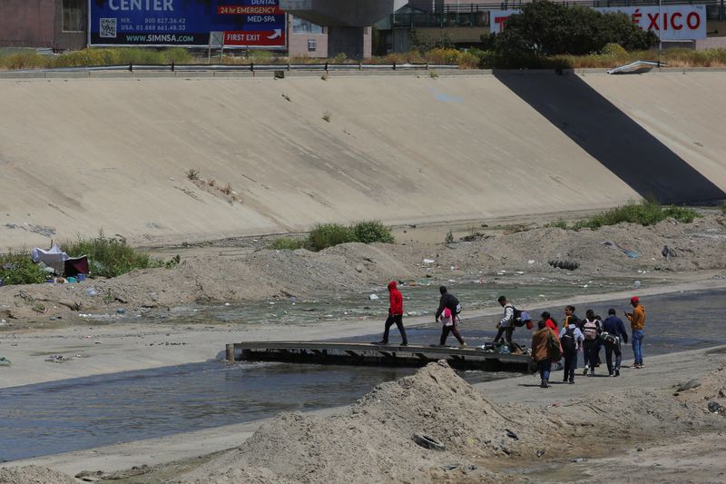 Un grupo de migrantes cruza un canal en Tijuana. REUTERS/Jorge Dueñas