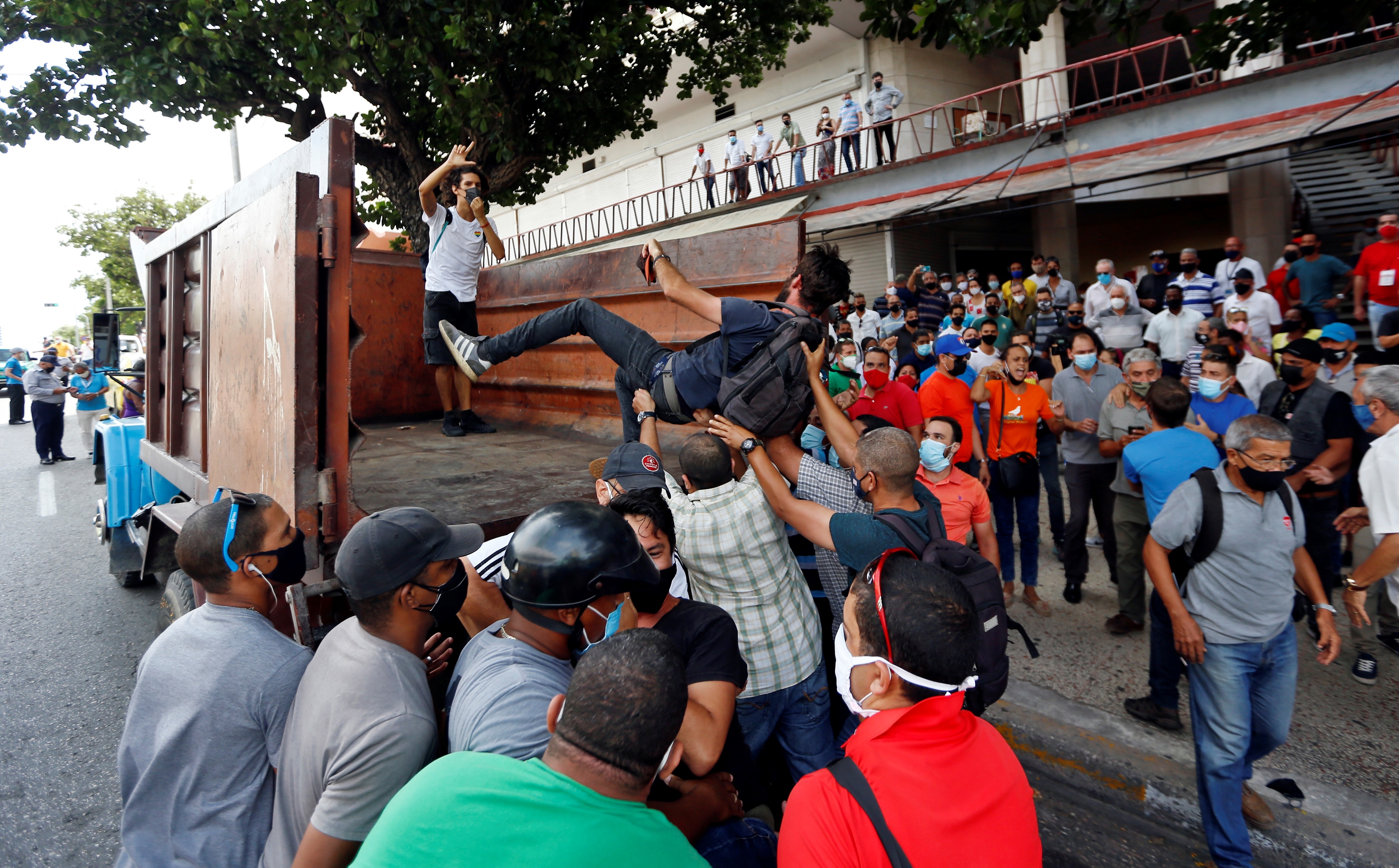 Manifestantes frente al Instituto de Radio y Televisión mientras son montados en un camión en una calle en La Habana (EFE/Ernesto Mastrascusa)
