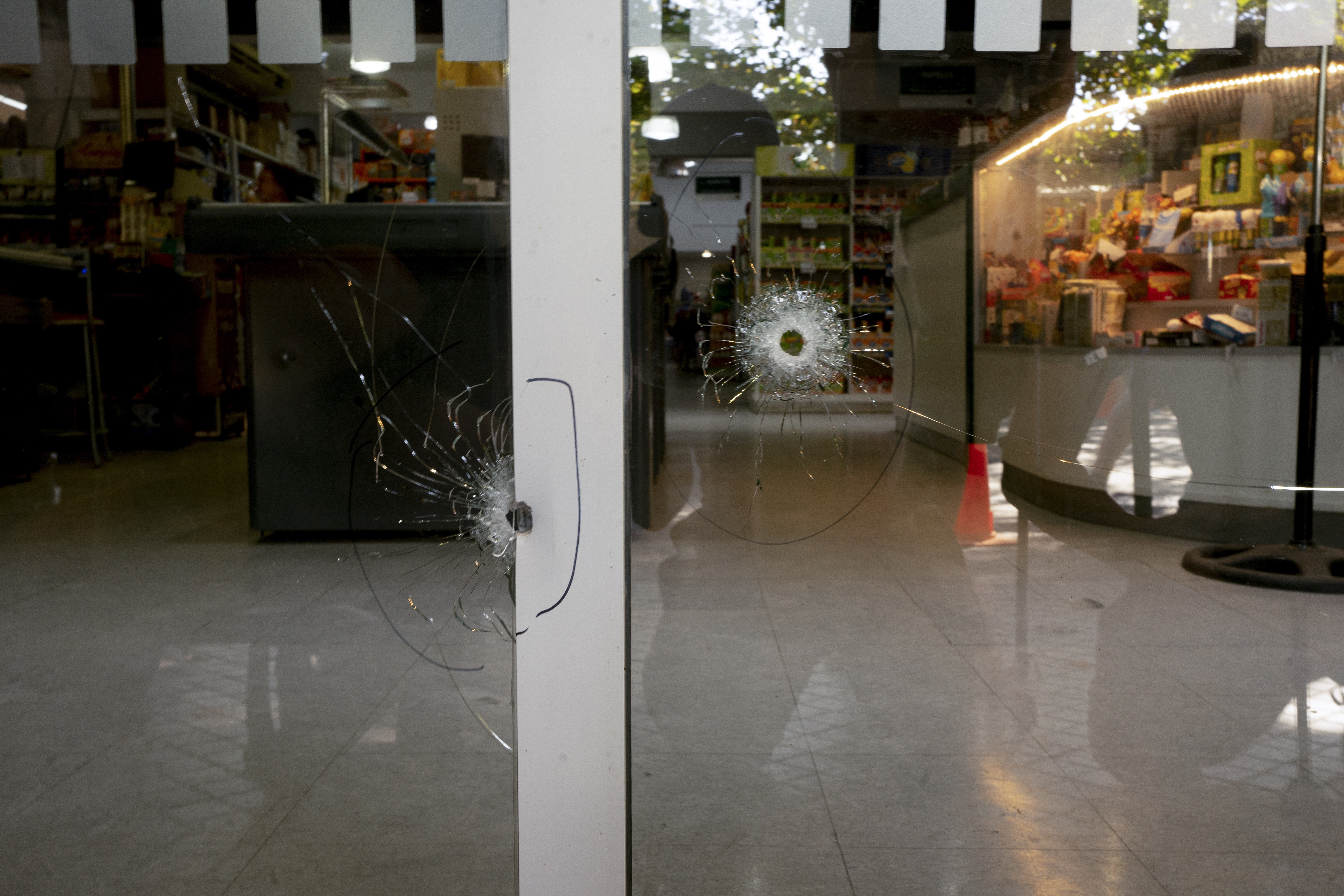 Los orificios de bala que impactaron las ventanas del supermercado Único, propiedad de la familia de la esposa de Lionel Messi, y que fue atacado a balazos