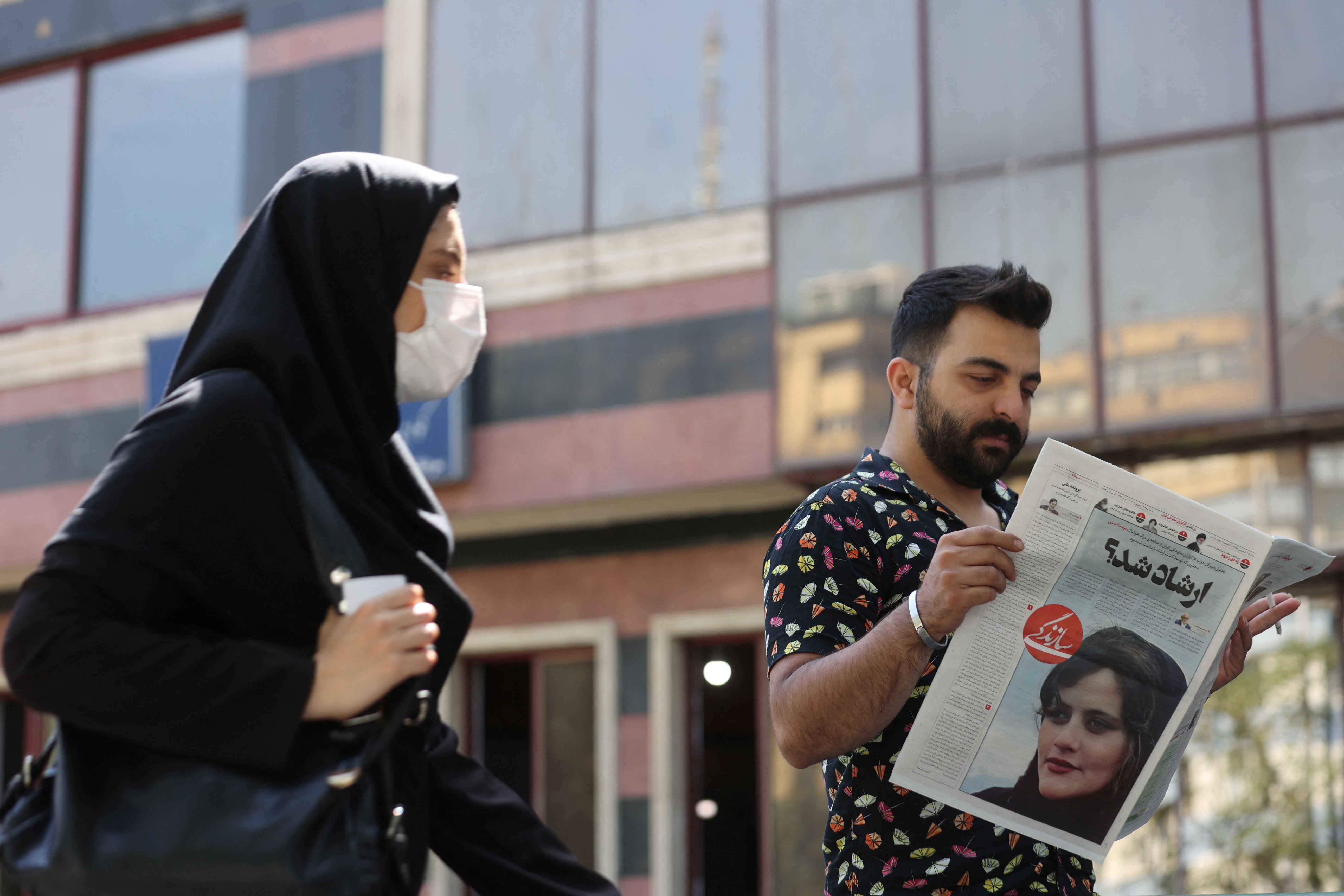 A man reads a newspaper with the cover photo of Mahsa Amini (Majid Asgaripour/WANA via REUTERS)