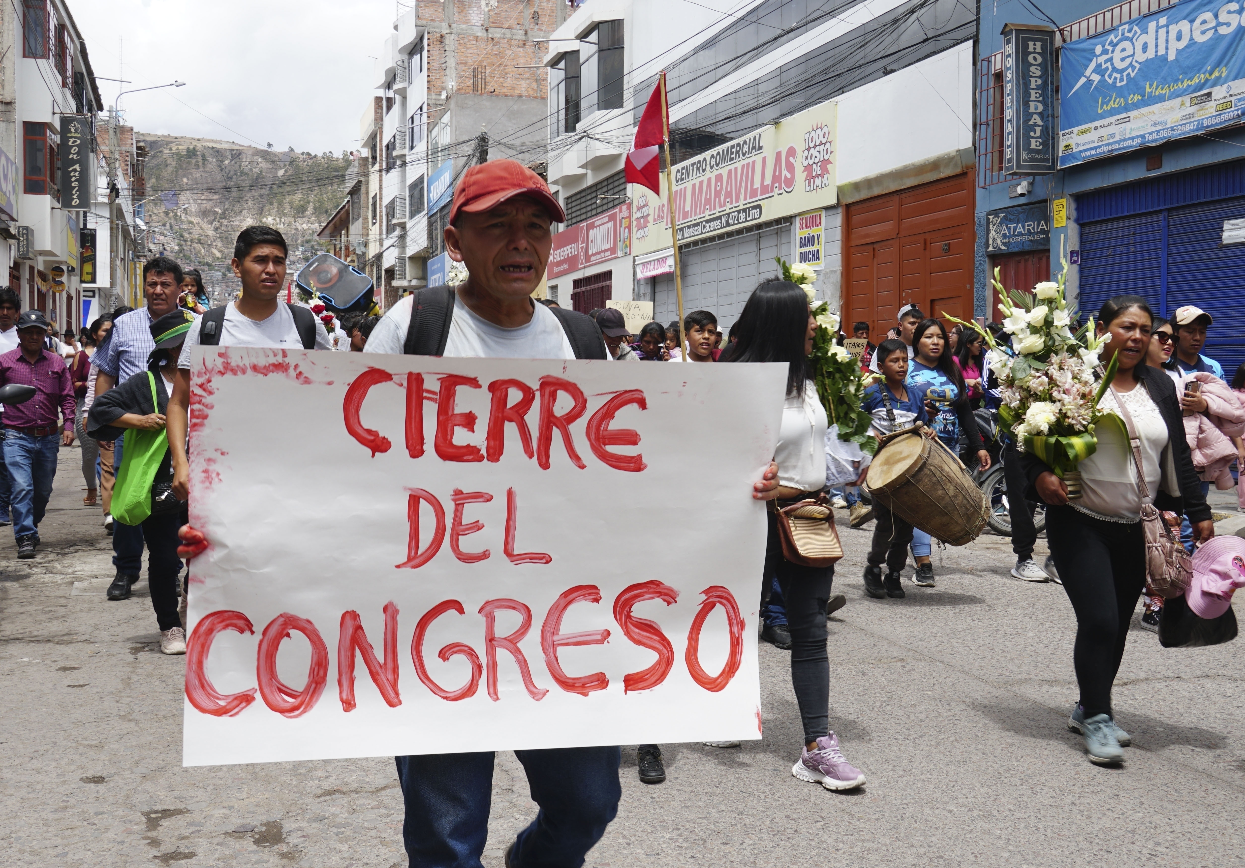 Un hombre camina con un cartel en el cortejo fúnebre de Clemer Rojas, de 23 años, que murió en las protestas contra la nueva presidenta Dina Boluarte, en Ayacucho, Perú, el sábado 17 de diciembre de 2022. (AP Foto/Franklin Briceño)