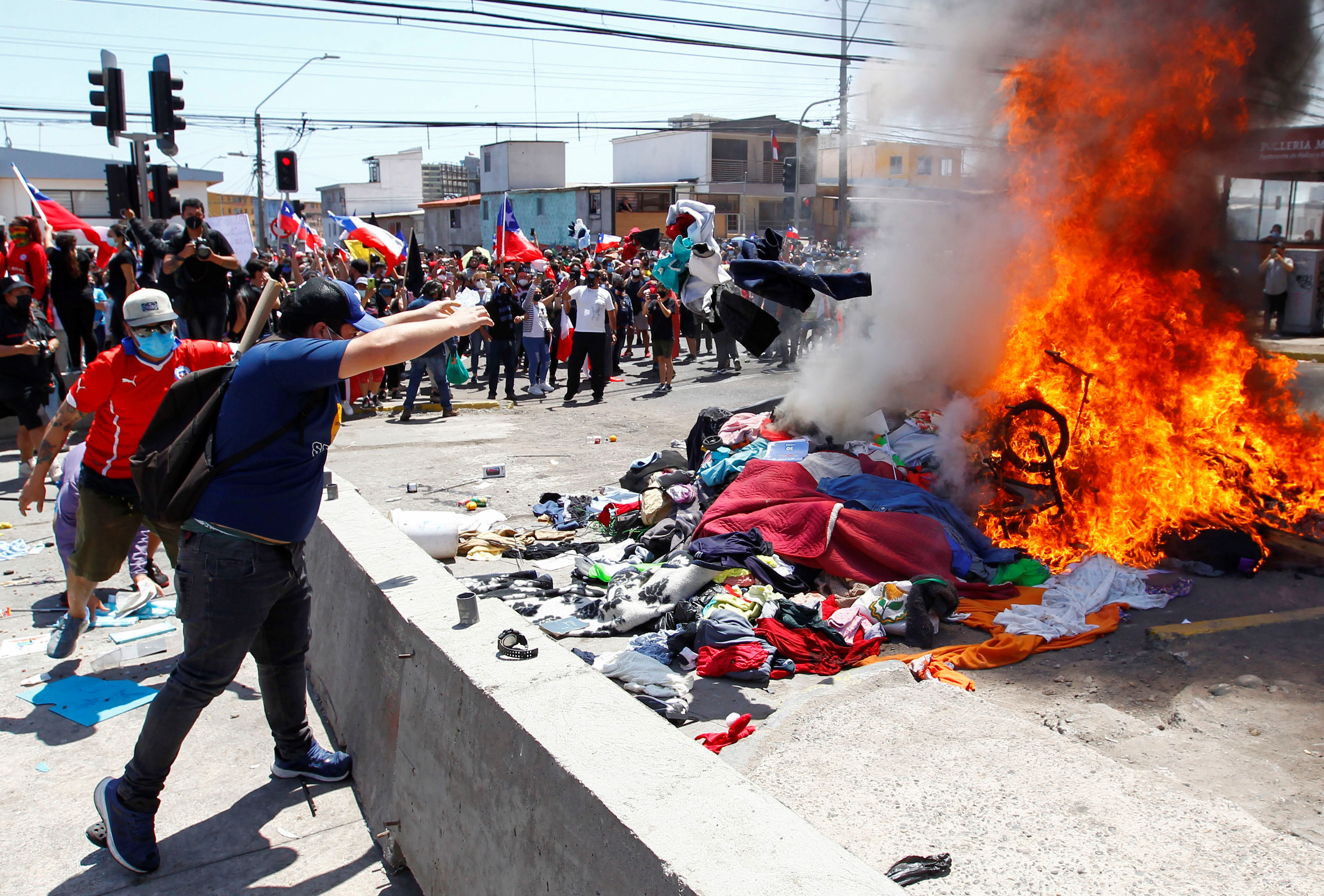 Manifestantes anti migración quemando objetos personales y enseres de un campamento improvisado de ciudadanos venezolanos en la ciudad de Iquique, Chile. REUTERS/Alex Diaz NO RESALES. NO ARCHIVES