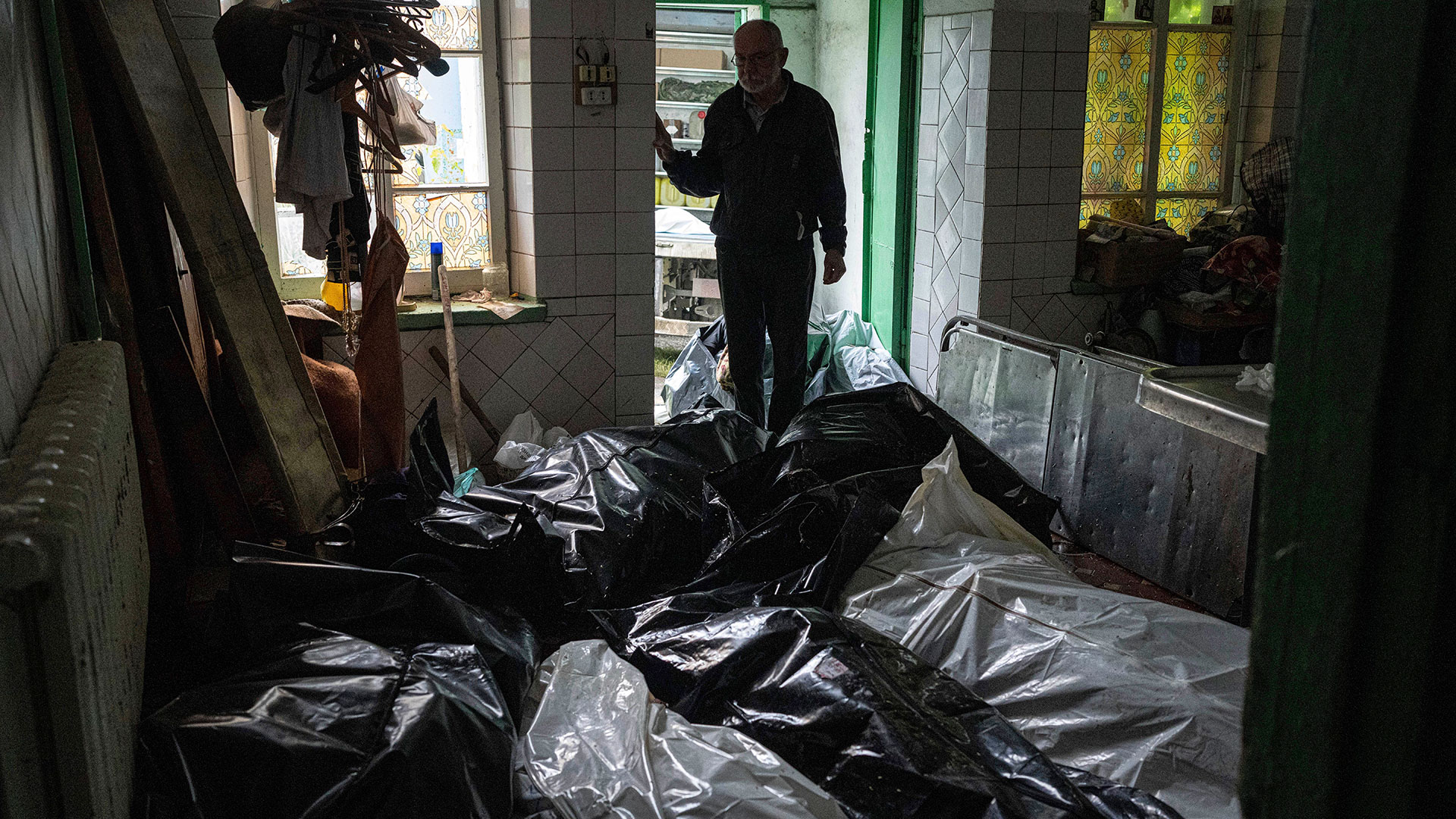 El Dr. Fedir Zdebskyi observa los cuerpos en bolsas de plástico en la morgue de Izium (Foto AP/Evgeniy Maloletka)