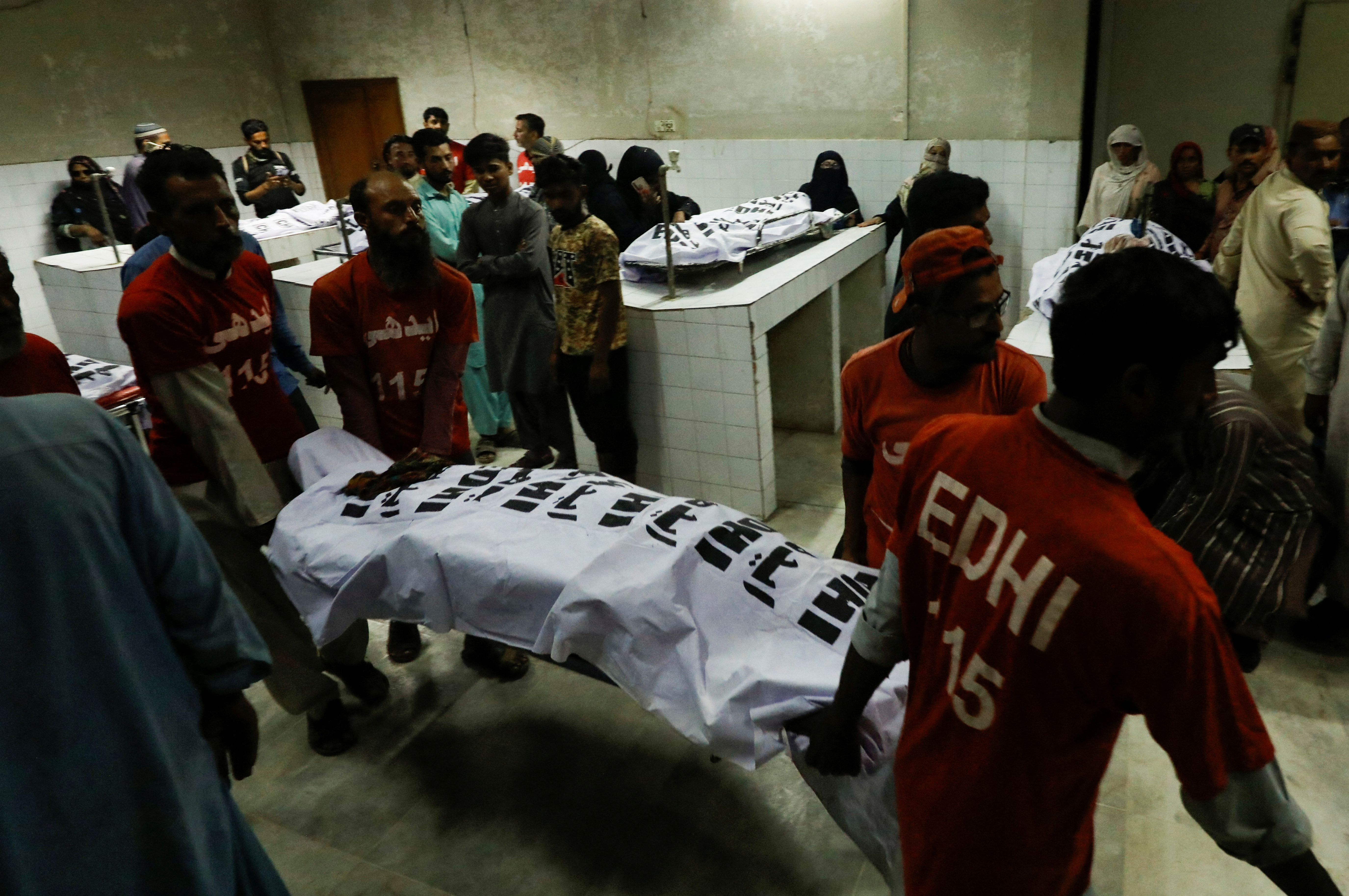 Rescatistas trasladan el cuerpo de una víctima de una estampida en la morgue de un hospital de Karachi, Pakistán (REUTERS/Akhtar Soomro)