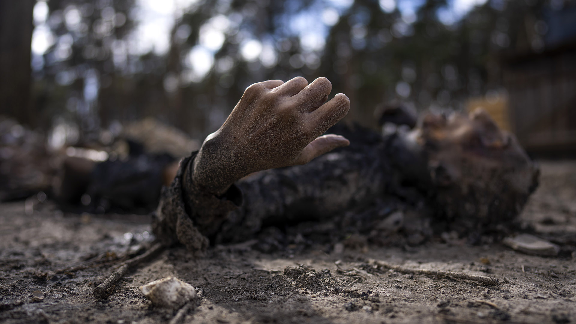 El cuerpo carbonizado de un hombre junto con otras cinco personas yace en el suelo en Bucha, en las afueras de Kiev